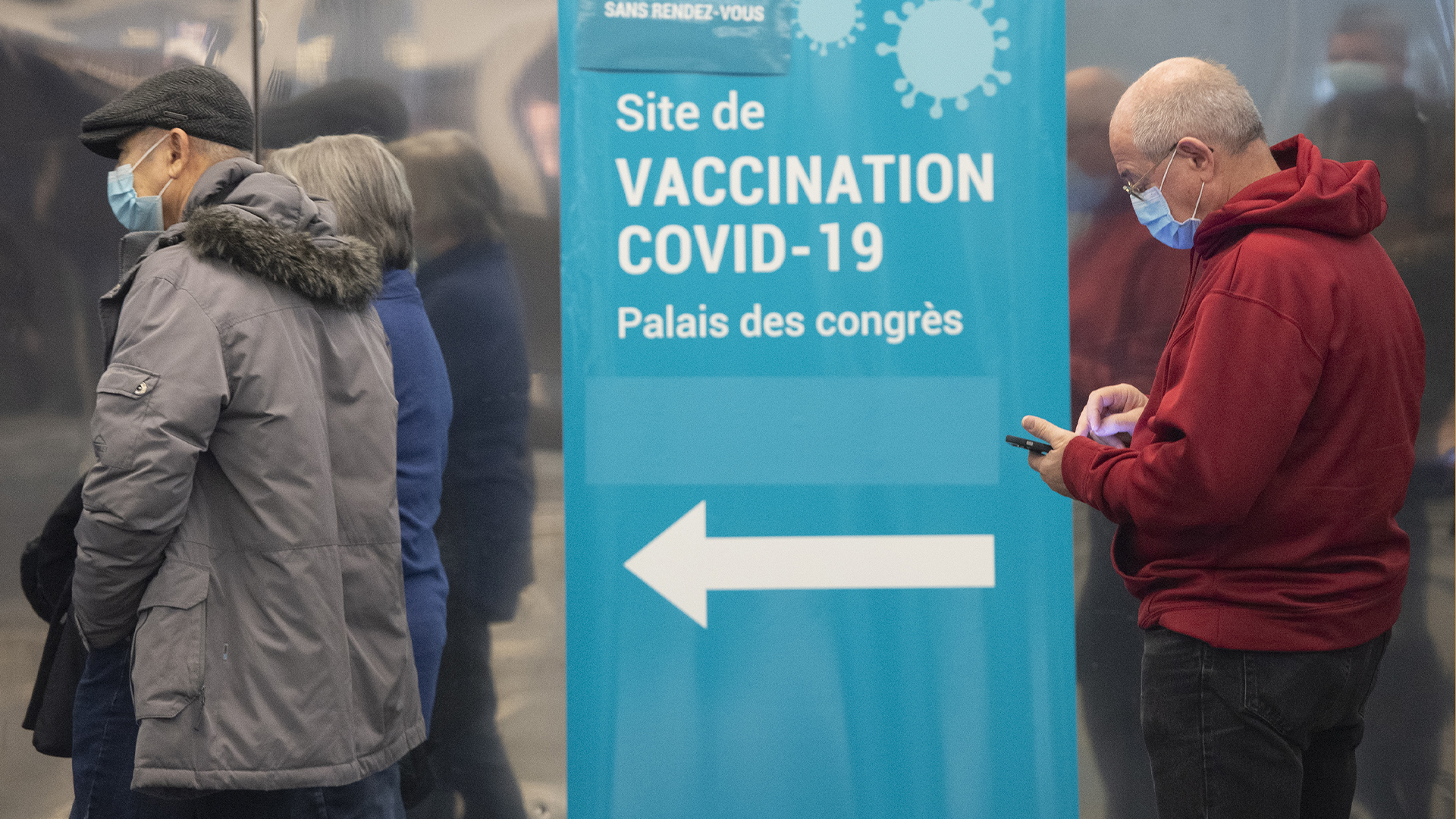 Les gens font la file au Palais des congrès afin de recevoir une dose de vaccin. 