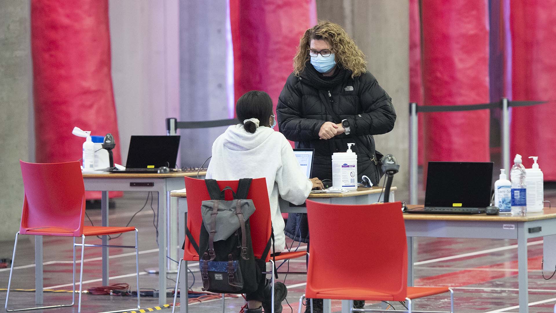 Entretien entre une travailleuse de la santé et une citoyenne dans un centre québécois de vaccination, le 8 janvier 2022.