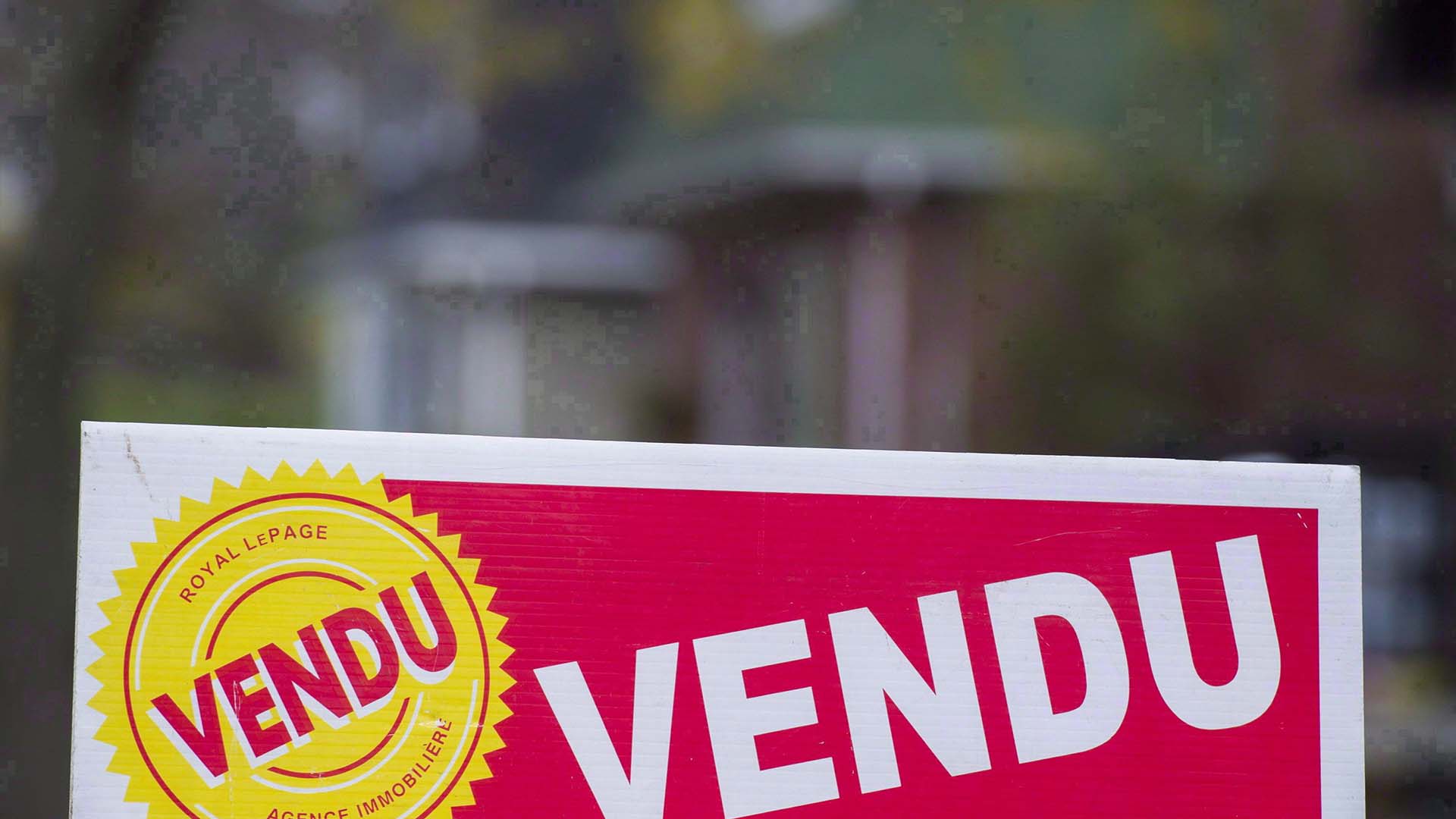 Une pancarte indiquant « vendu » en français est affichée sur l'ouest de l'île de Montréal.