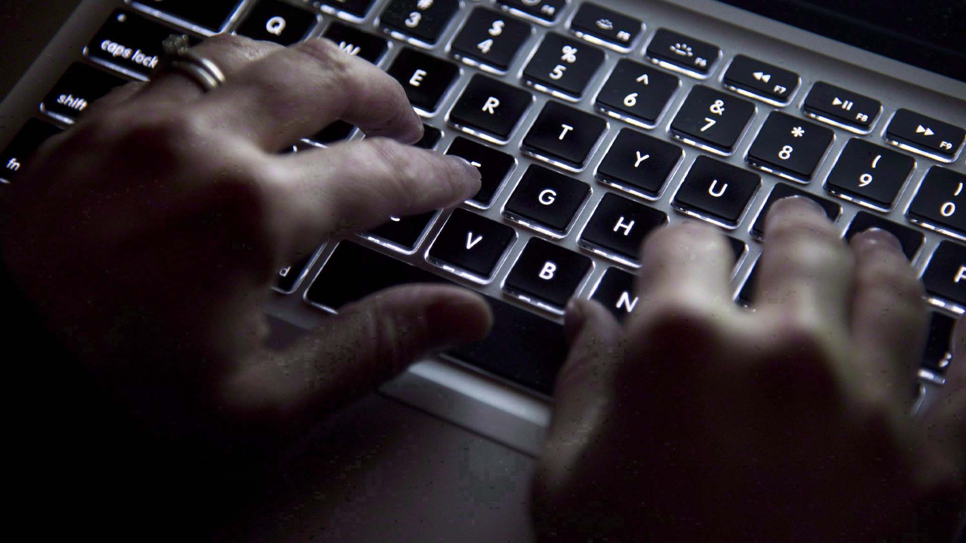 Une femme utilise son clavier d'ordinateur pour taper tout en surfant sur Internet.