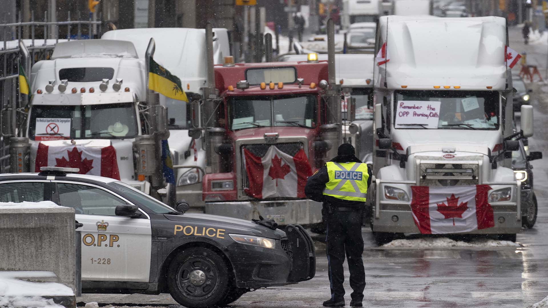 La police monte une barricade devant des véhicules stationnés dans le cadre de la manifestation des camionneurs, le mardi 8 février 2022 au centre-ville d'Ottawa.