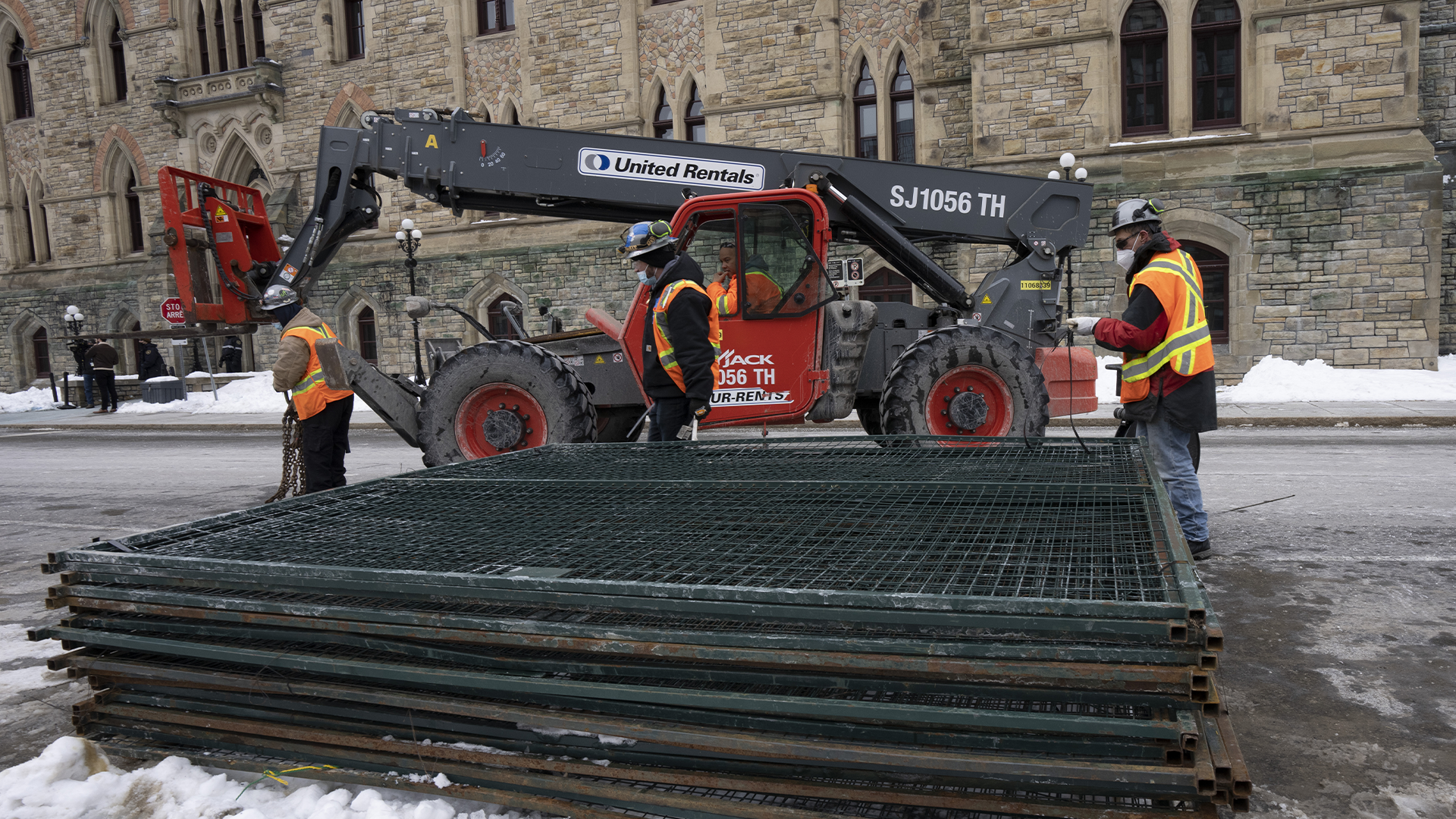 Des ouvriers retirent la clôture devant le Parlement, le lundi 21 février 2022 à Ottawa. 