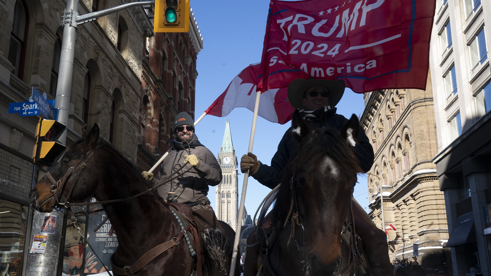 Deux manifestants à cheval près des camions stationnés et la Colline du Parlement lors de la manifestation contre les restrictions liées à la COVID-19, à Ottawa, le samedi 5 février 2022.