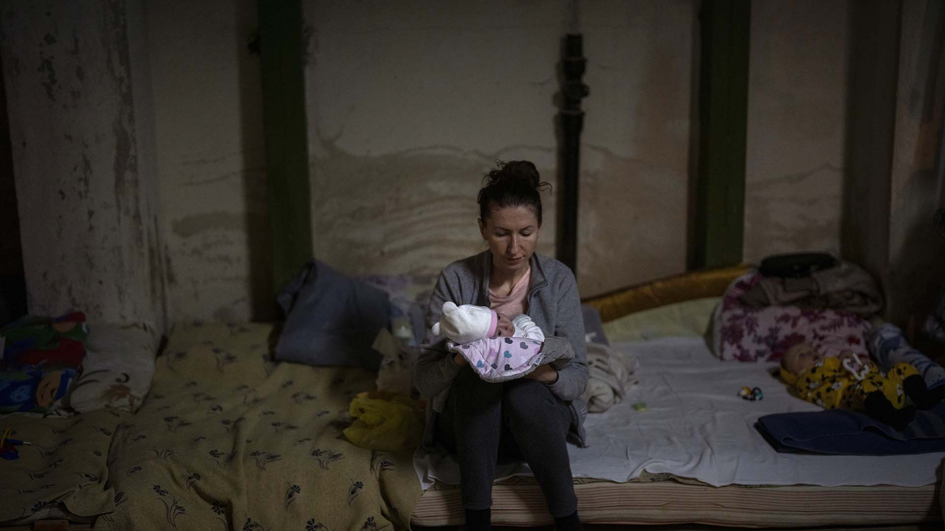 Une femme tient son nouveau-né dans un sous-sol utilisé comme abri antibombes à l'hôpital pour enfants d'Okhmadet, dans le centre de Kiev, en Ukraine, le lundi 28 février 2022. 