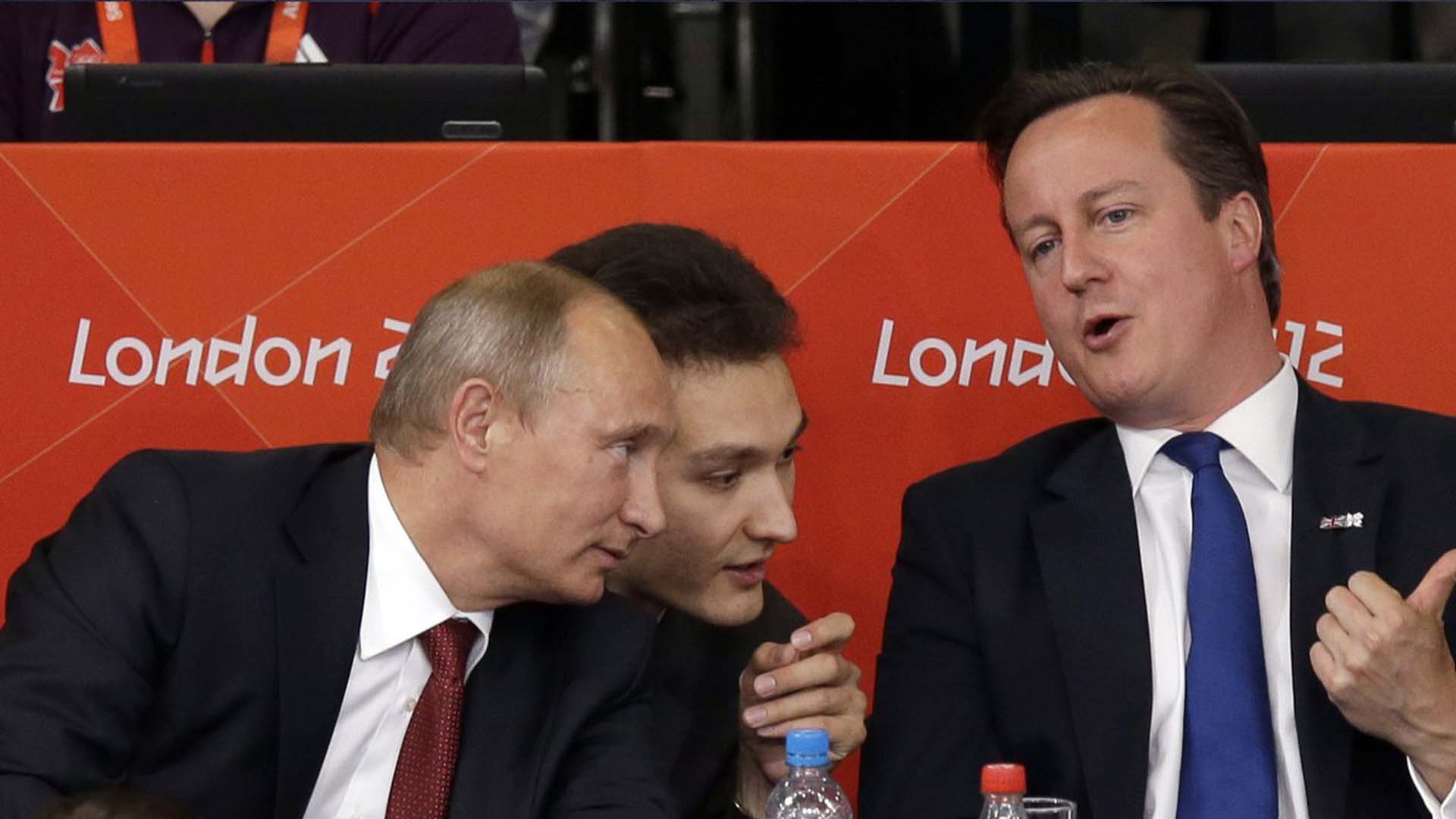 Le président russe Vladmir Poutine, à gauche, et le Premier ministre britannique David Cameron regardent le judo lors de la compétition masculine de judo de 100 kg aux Jeux olympiques d'été de 2012, le 2 août 2012, à Londres.