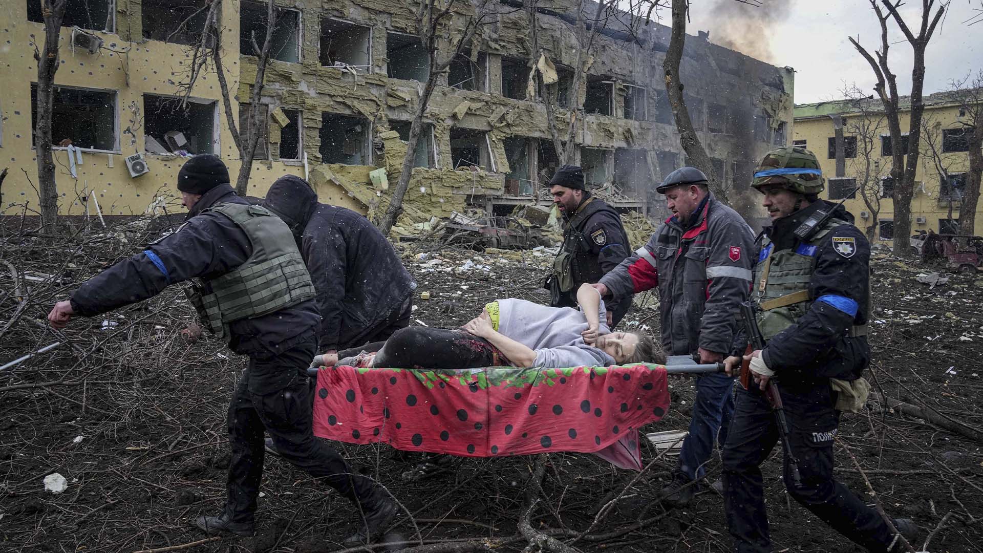Des employés d'urgence transportent une femme enceinte blessée d'une maternité endommagée par des bombardements à Marioupol, le mercredi 9 mars 2022. La mère et le bébé sont décédés.