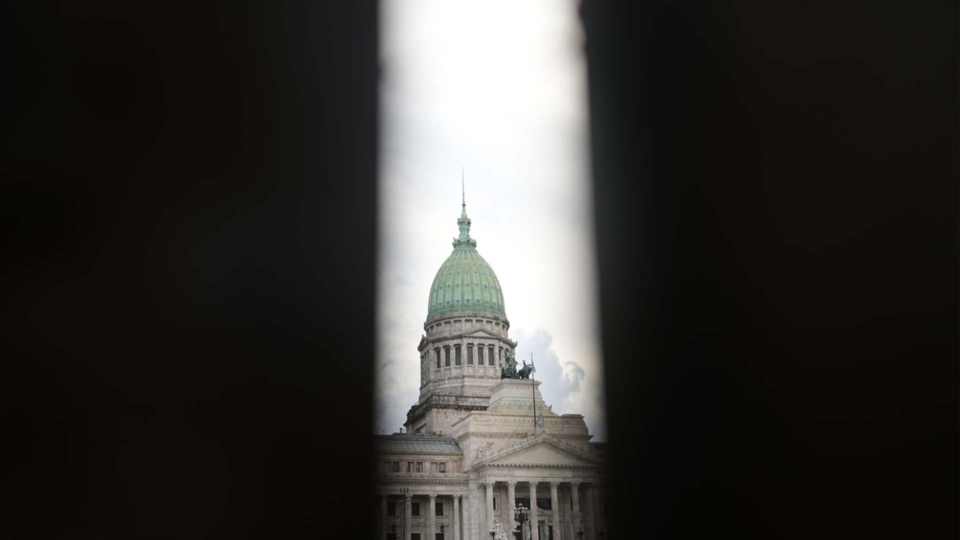 Le bâtiment du Congrès argentin est encadré par une ouverture de clôture alors que les sénateurs se préparent à voter sur l'opportunité de ratifier l'accord du gouvernement avec le Fonds monétaire international pour refinancer quelque 45 milliards de dollars de dette, à Buenos Aires, en Argentine, le jeudi 17 mars 2022.