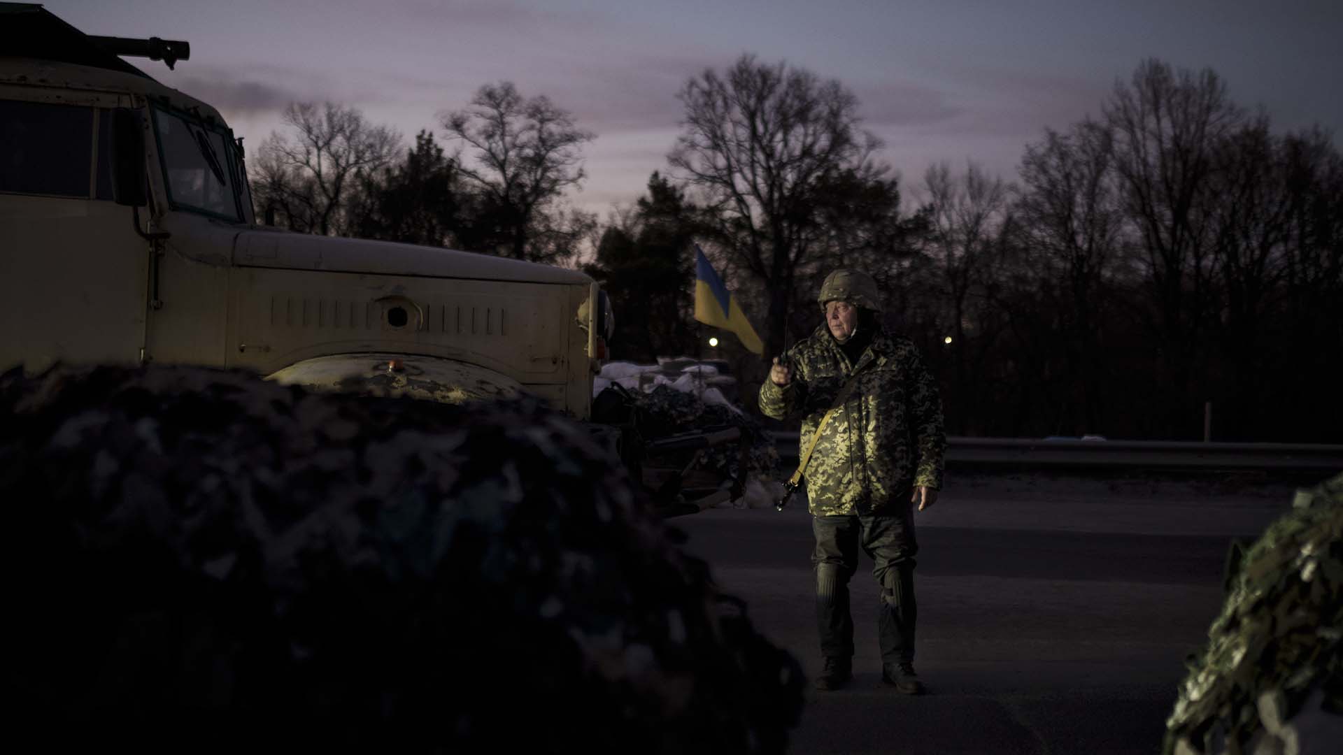 Un volontaire des Forces de défense territoriale ukrainiennes se tient à un poste de contrôle à Brovary, au nord-est de Kyiv, en Ukraine, le lundi 21 mars 2022.