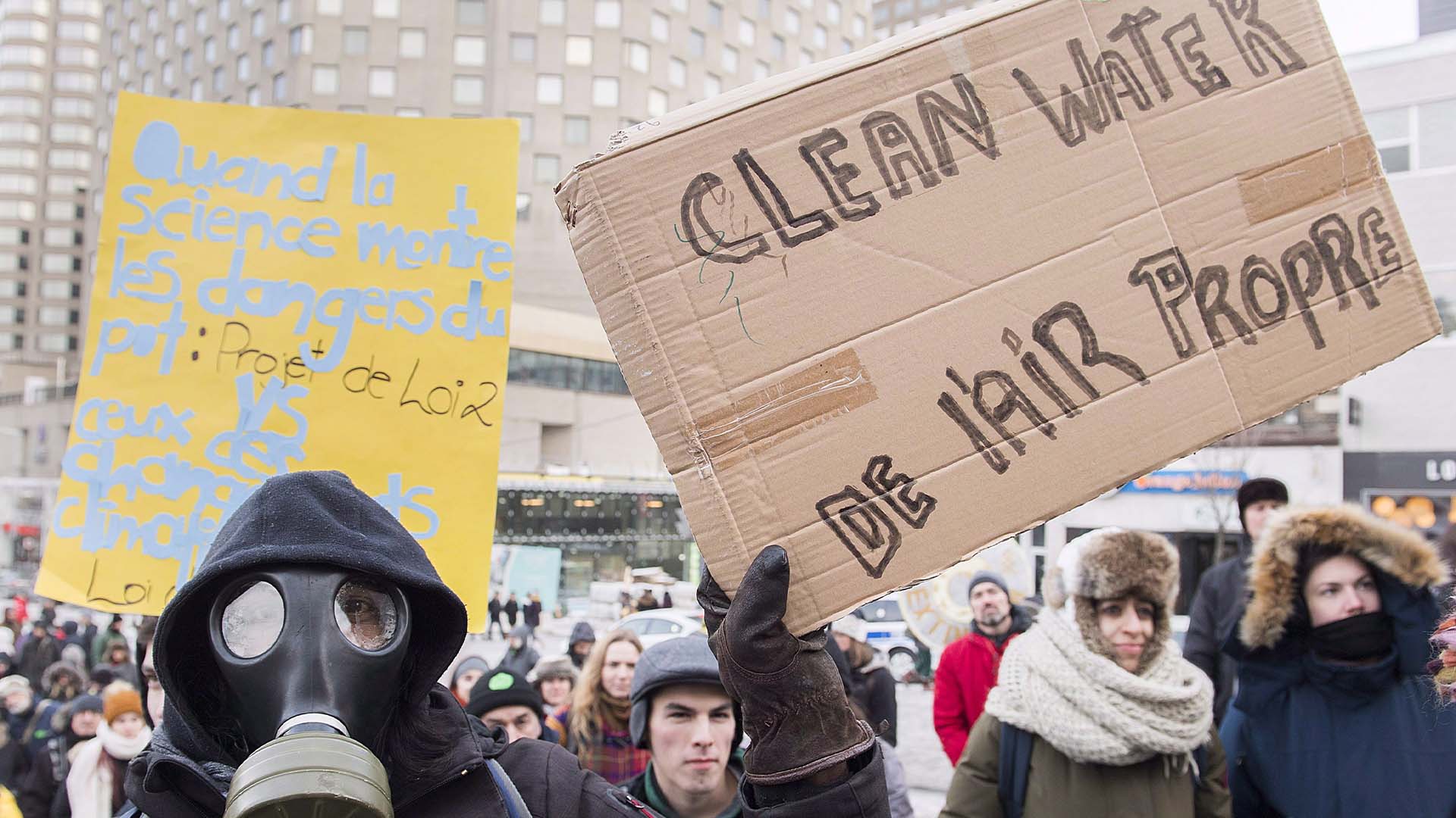 Des gens brandissent des pancartes exigeant des mesures contre les changements climatiques lors d'une manifestation à Montréal, le samedi 8 décembre 2018.