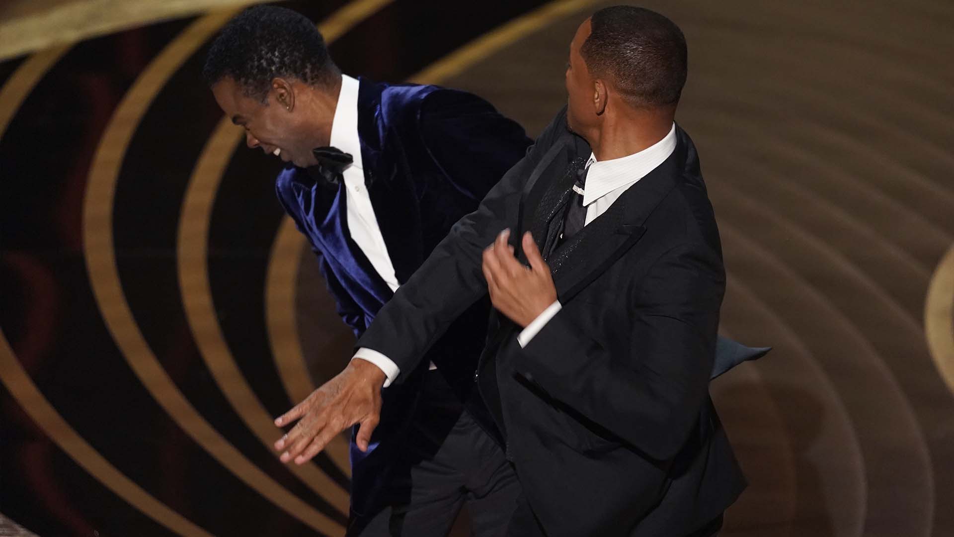 Will Smith, à droite, frappe le présentateur Chris Rock sur scène tout en remettant le prix du meilleur long métrage documentaire aux Oscars le dimanche 27 mars 2022, au Dolby Theatre de Los Angeles.