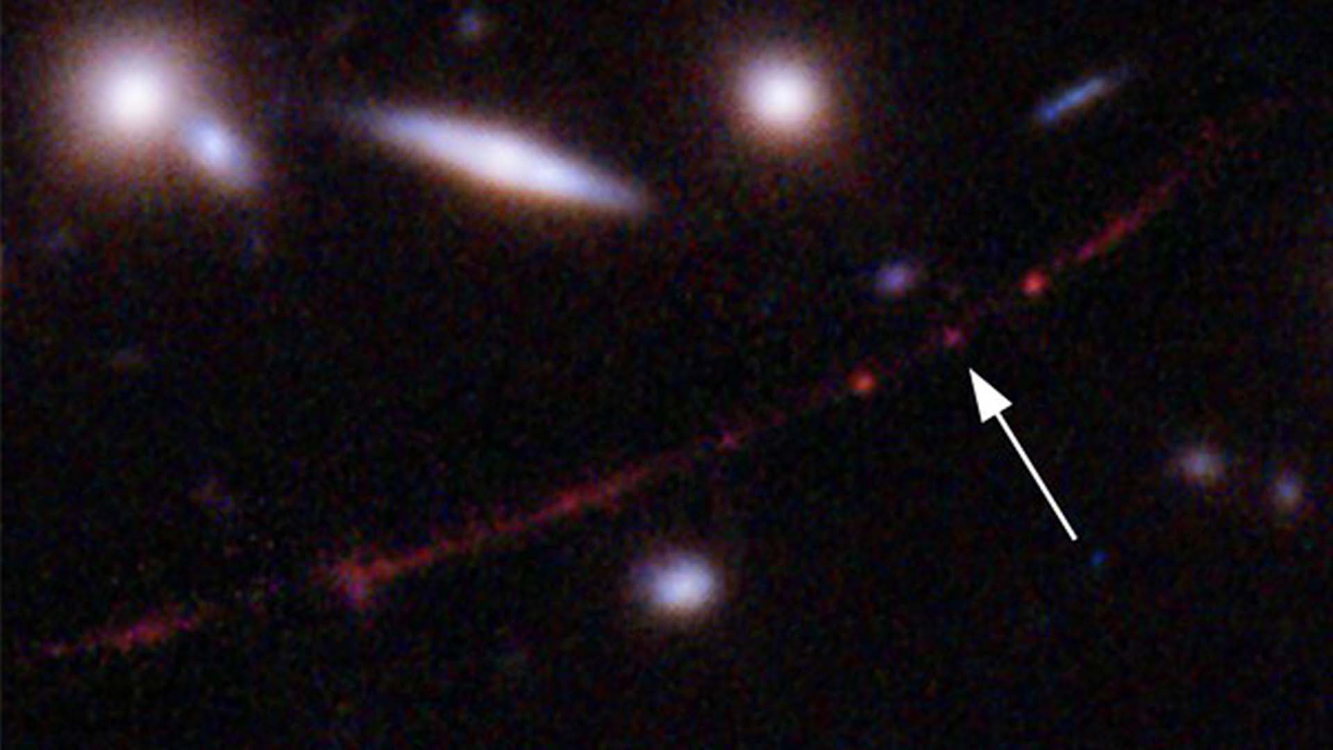 Cette image mise à disposition par la NASA le mercredi 30 mars 2022 montre l'étoile «Earendel», indiquée par une flèche, et la galaxie Sunrise Arc, s'étendant du bas à gauche au haut à droite, optiquement pliée en raison d'un amas de galaxies massif entre elle et le Hubble Télescope spatial qui a capturé la lumière. La masse de l'amas de galaxies sert de loupe, permettant à l'étoile d'être vue.