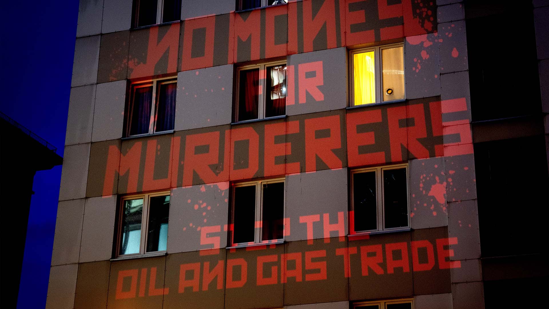 Les mots «Pas d'argent pour les meurtriers, arrêtez le commerce du pétrole et du gaz» sont projetés par des militants sur le consulat russe à Francfort, en Allemagne, le lundi 4 avril 2022. 