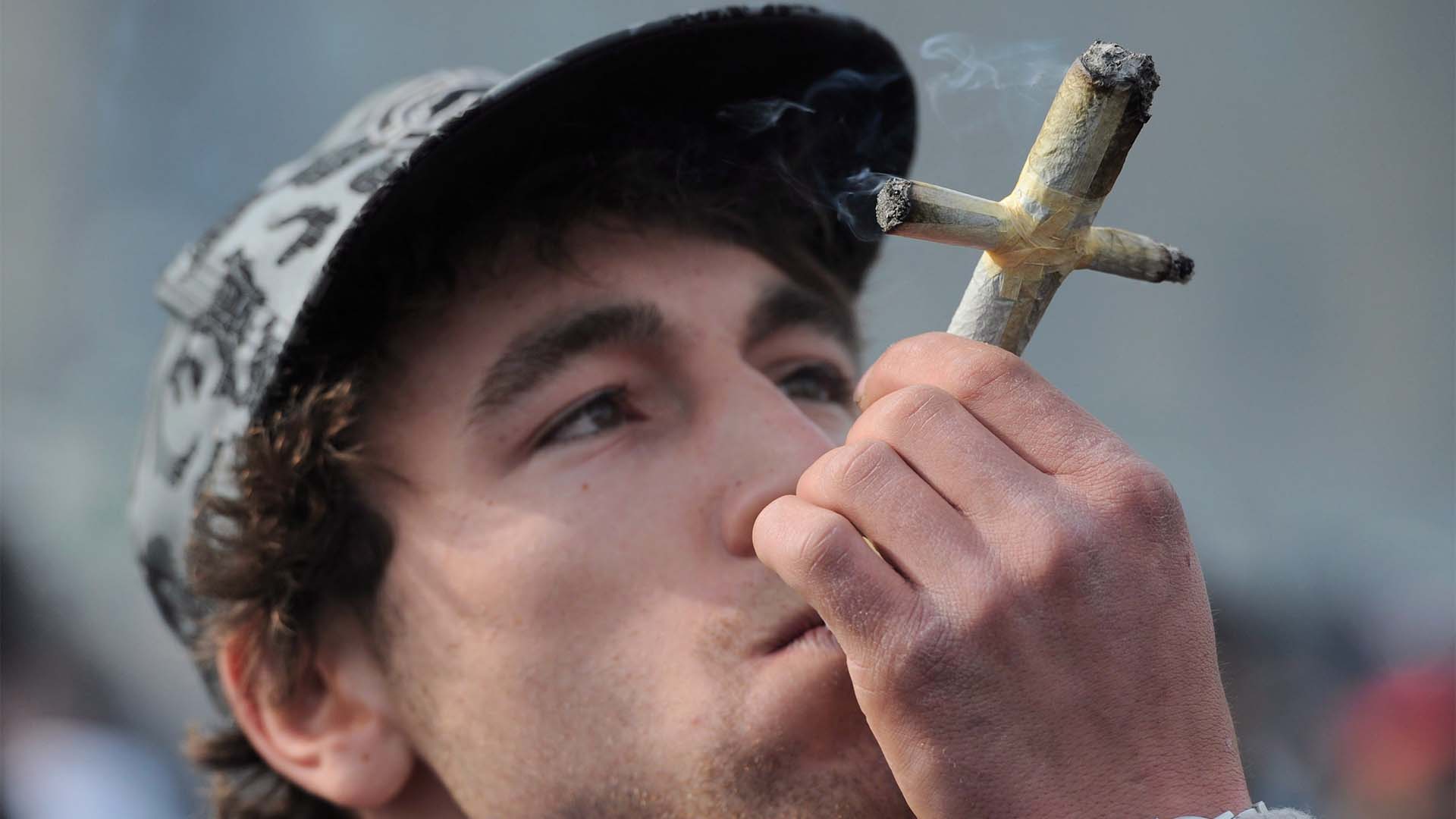 Un homme fume un joint alors qu'il participe au rassemblement 4-20 sur la Colline du Parlement à Ottawa