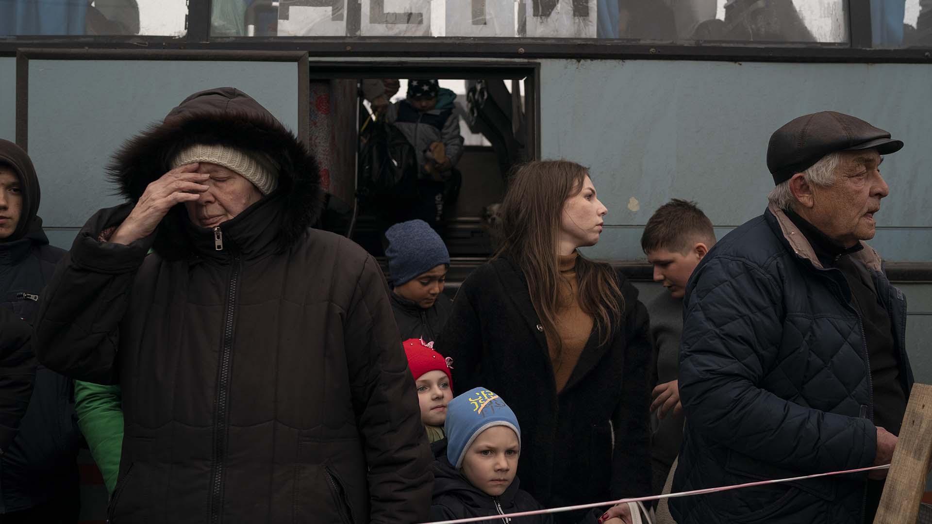 Des habitants de Marioupol et des villes voisines sortent d'un bus, avec une pancarte sur la fenêtre indiquant en russe : «Enfants», et arrivent dans un centre de réfugiés fuyant la guerre, à Zaporizhzhia, en Ukraine, le jeudi 21 avril 2022. 