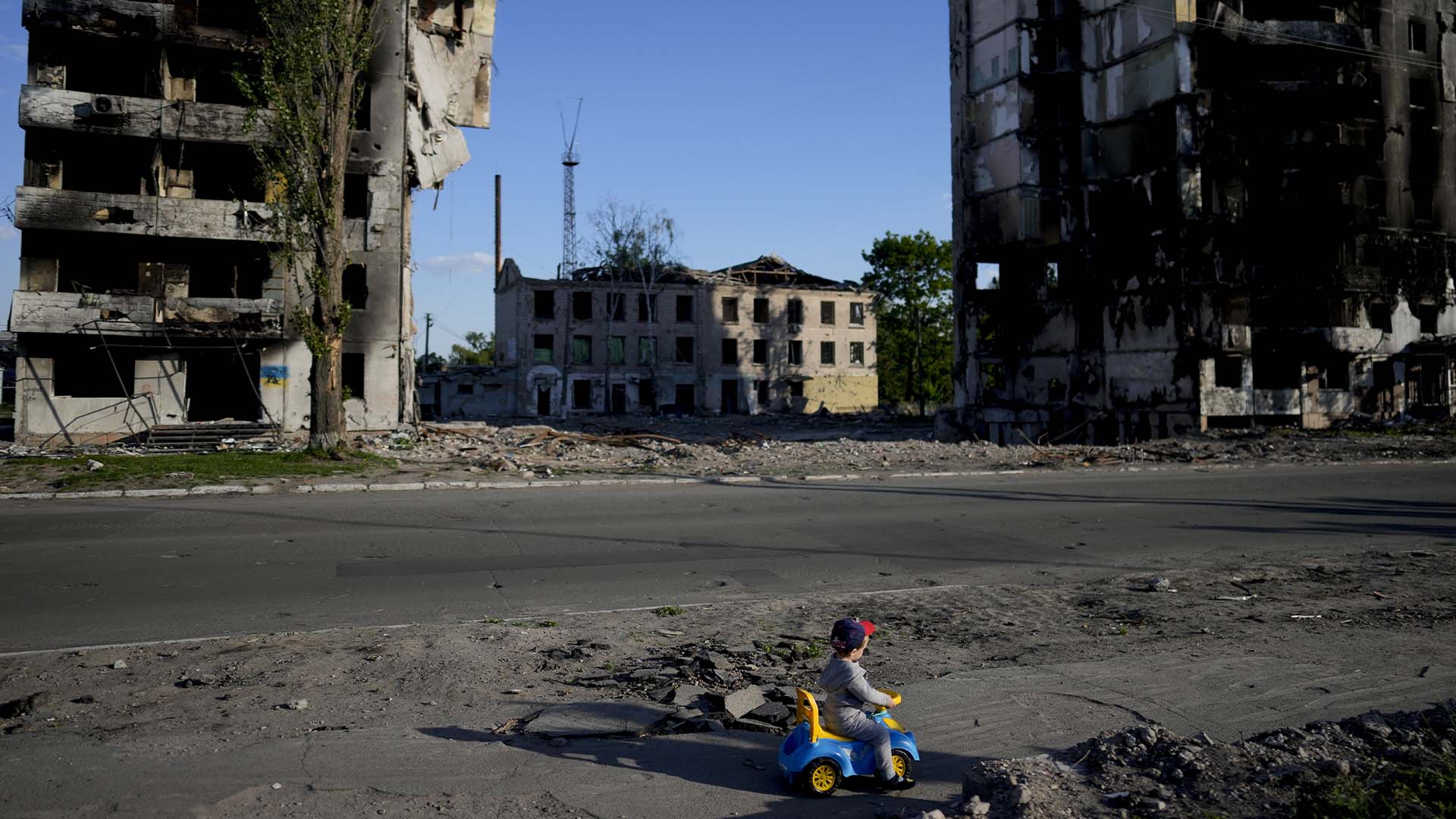 Un garçon joue devant des maisons détruites par les bombardements à Borodyanka, en Ukraine, le mardi 24 mai 2022.