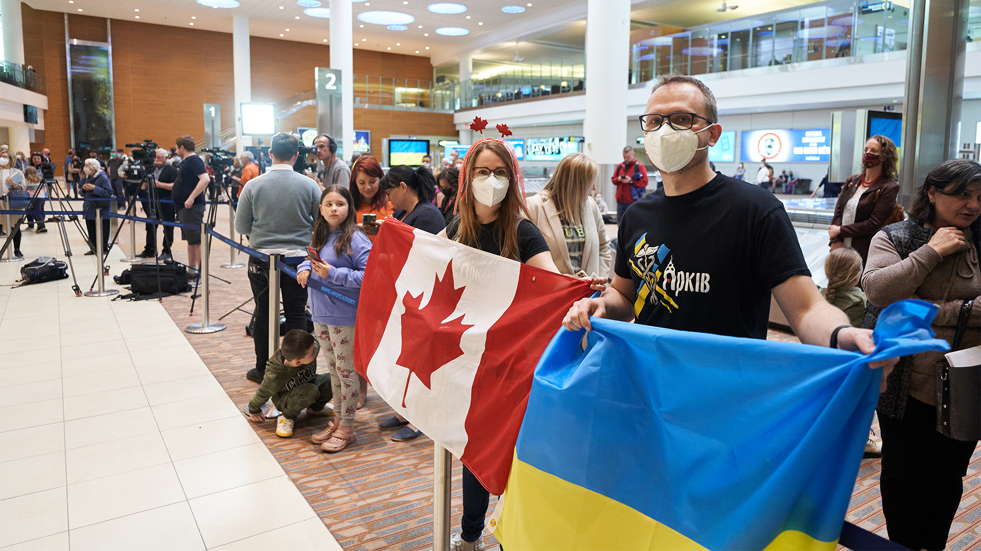 Natalie et Paul Bebedev accueillent des réfugiés ukrainiens à l'aéroport international de Richardson, à Winnipeg.