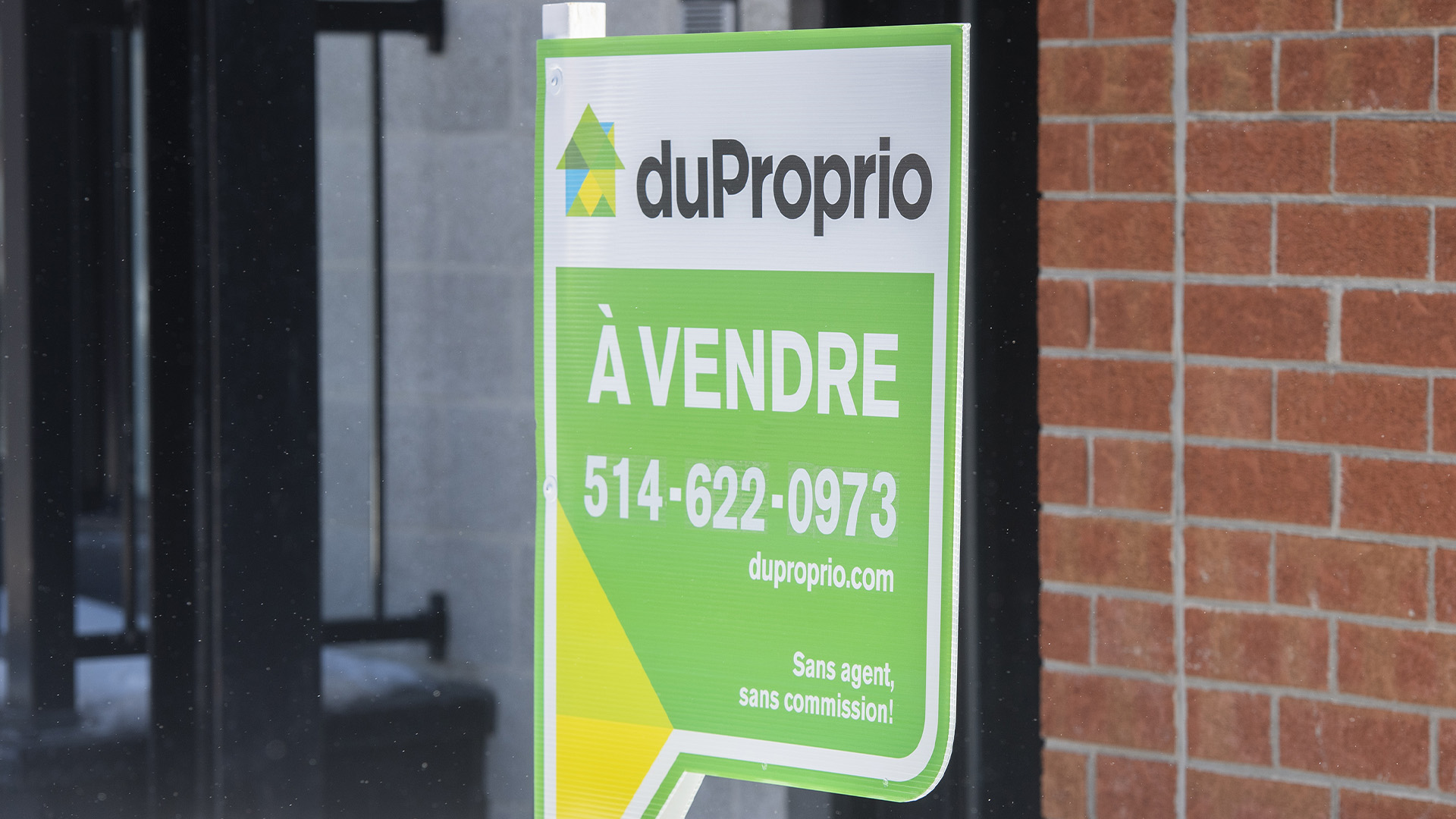 Une pancarte annonçant la vente d'un condo est exposée à Montréal.