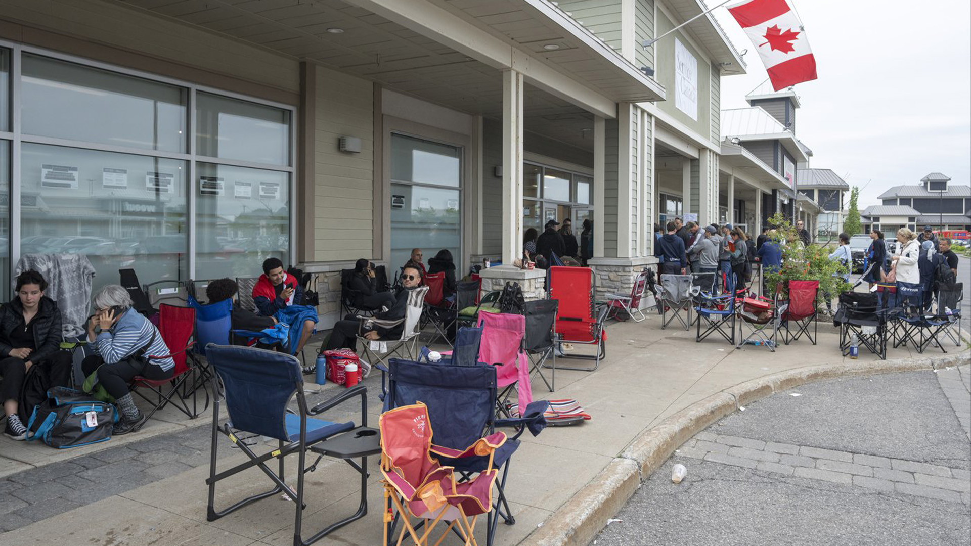 Des gens font la queue au bureau des passeports, le mardi 21 juin 2022 à Laval, au Québec.