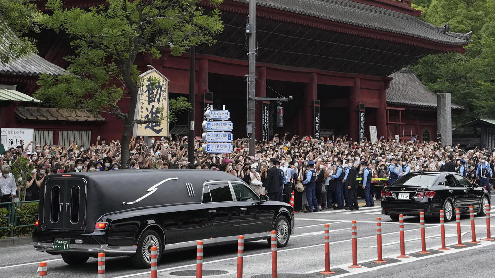 Le véhicule, à gauche, transportant le corps de l'ancien Premier ministre japonais Shinzo Abe quitte le temple Zojoji après ses funérailles à Tokyo le mardi 12 juillet 2022. Abe a été assassiné vendredi alors qu'il faisait campagne à Nara, dans l'ouest du Japon.
