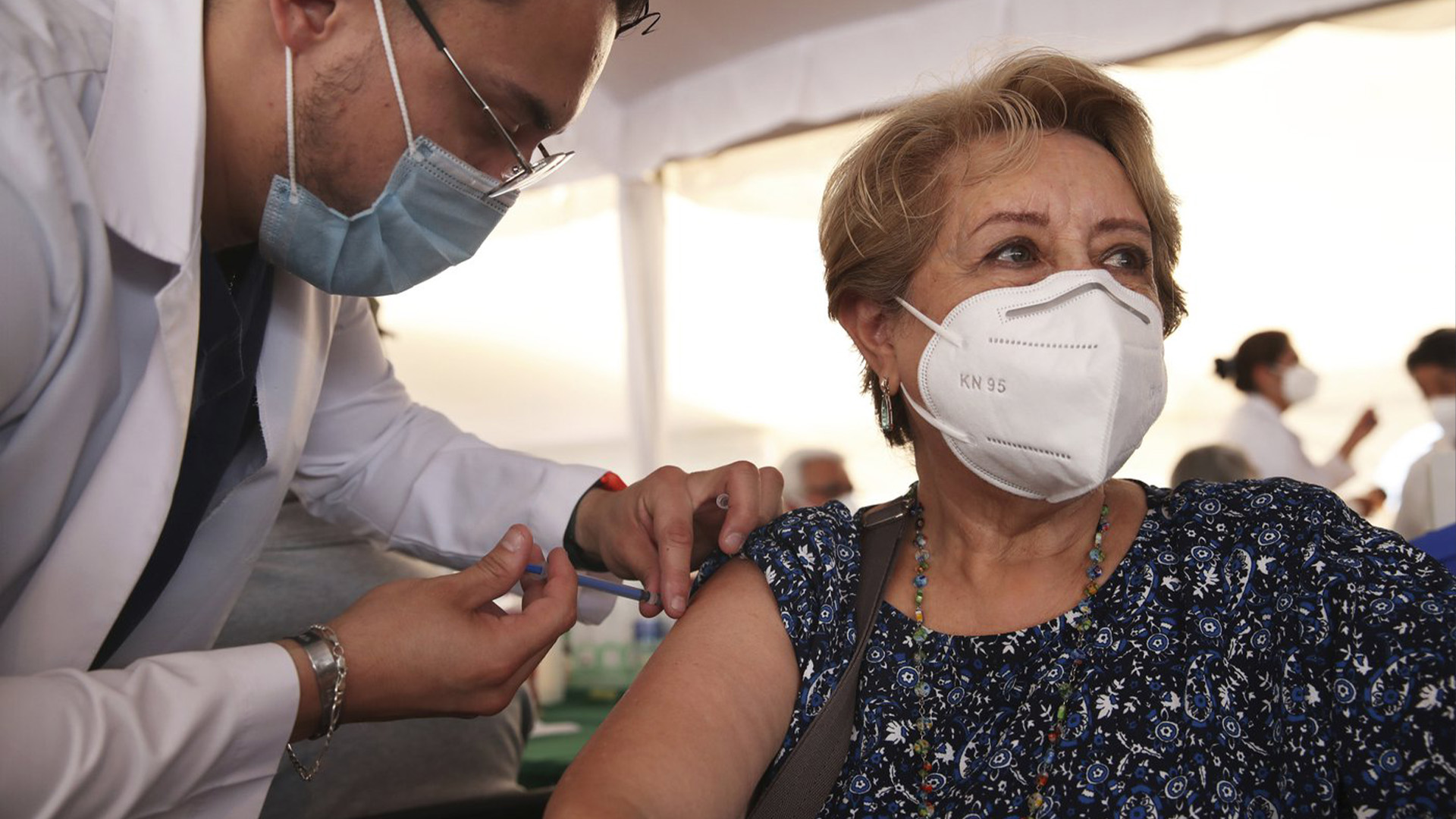 Un agent de santé inocule à une femme la deuxième dose du vaccin AstraZeneca COVID-19, lors d'une campagne de vaccination pour les personnes de plus de 60 ans, au stade olympique universitaire de Mexico, le lundi 12 avril 2021.