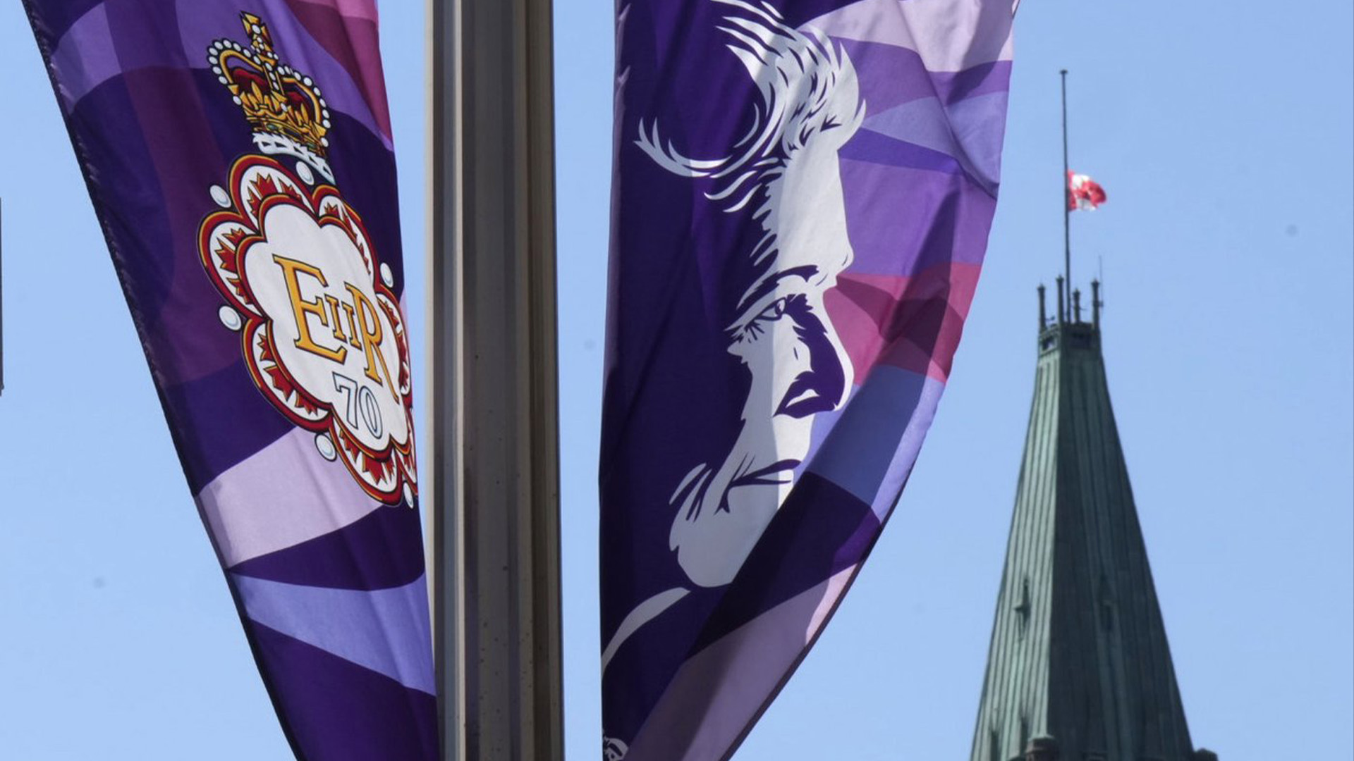 Le drapeau de la tour de la Paix flotte en berne derrière les bannières de la reine Elizabeth célébrant le jubilé de platine, à Ottawa, le jeudi 8 septembre 2022. Les députés de toutes les allégeances politiques devraient se lever en hommage à feu la reine Elizabeth lors d'une séance spéciale de la Chambre des communes.