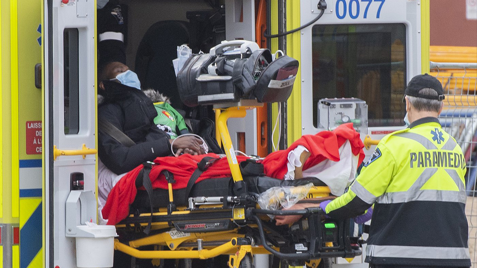 Des ambulanciers paramédicaux transfèrent une personne d'une ambulance à un hôpital, au milieu de la pandémie mondiale de COVID-19, à Montréal, le samedi 18 décembre 2021.