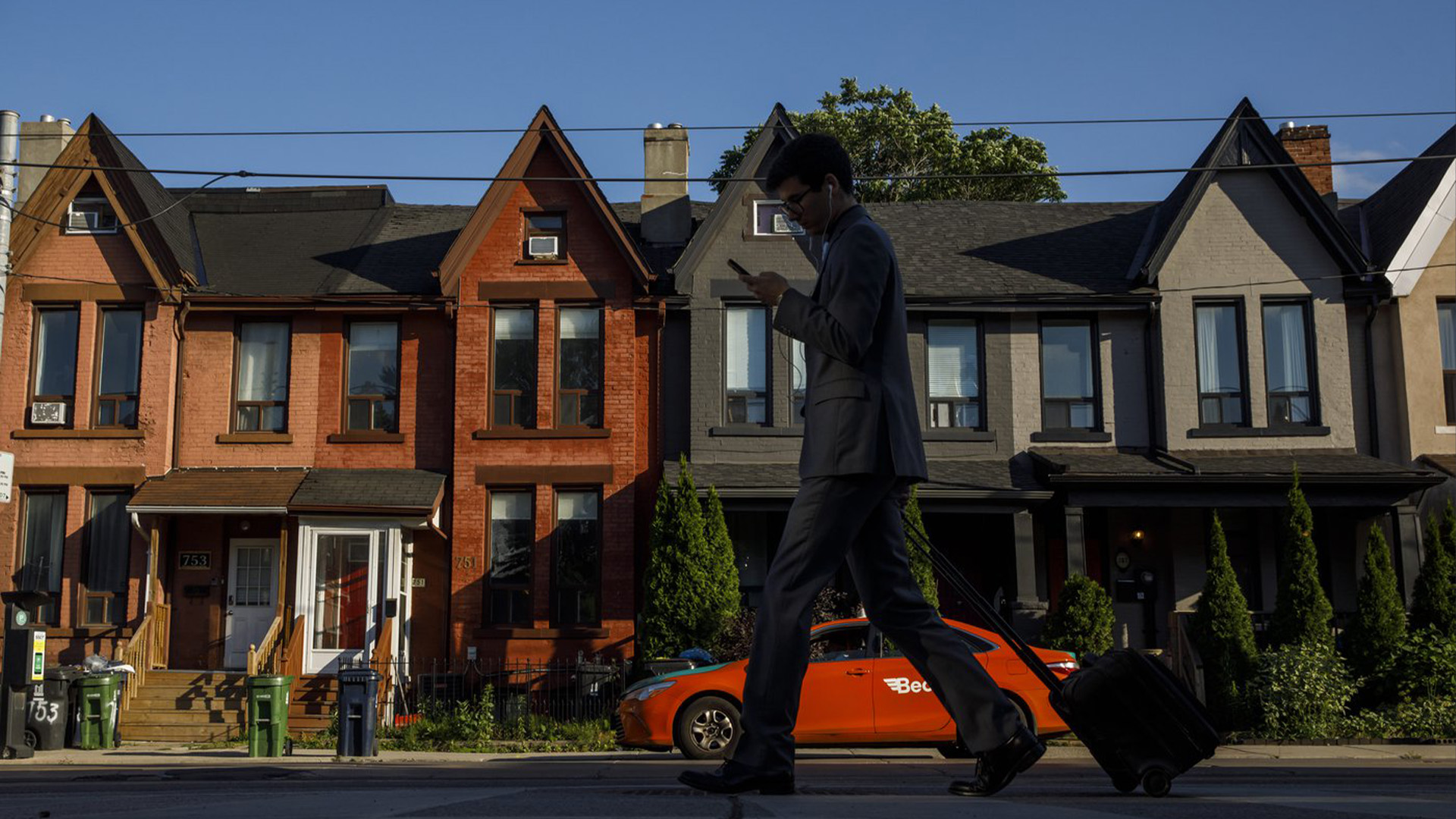 Une personne passe devant une rangée de maisons à Toronto le mardi 12 juillet 2022. Les multigénérations vivant sous un même toit sont de plus en plus courantes, a révélé mercredi la dernière tranche de données du recensement de Statistique Canada.