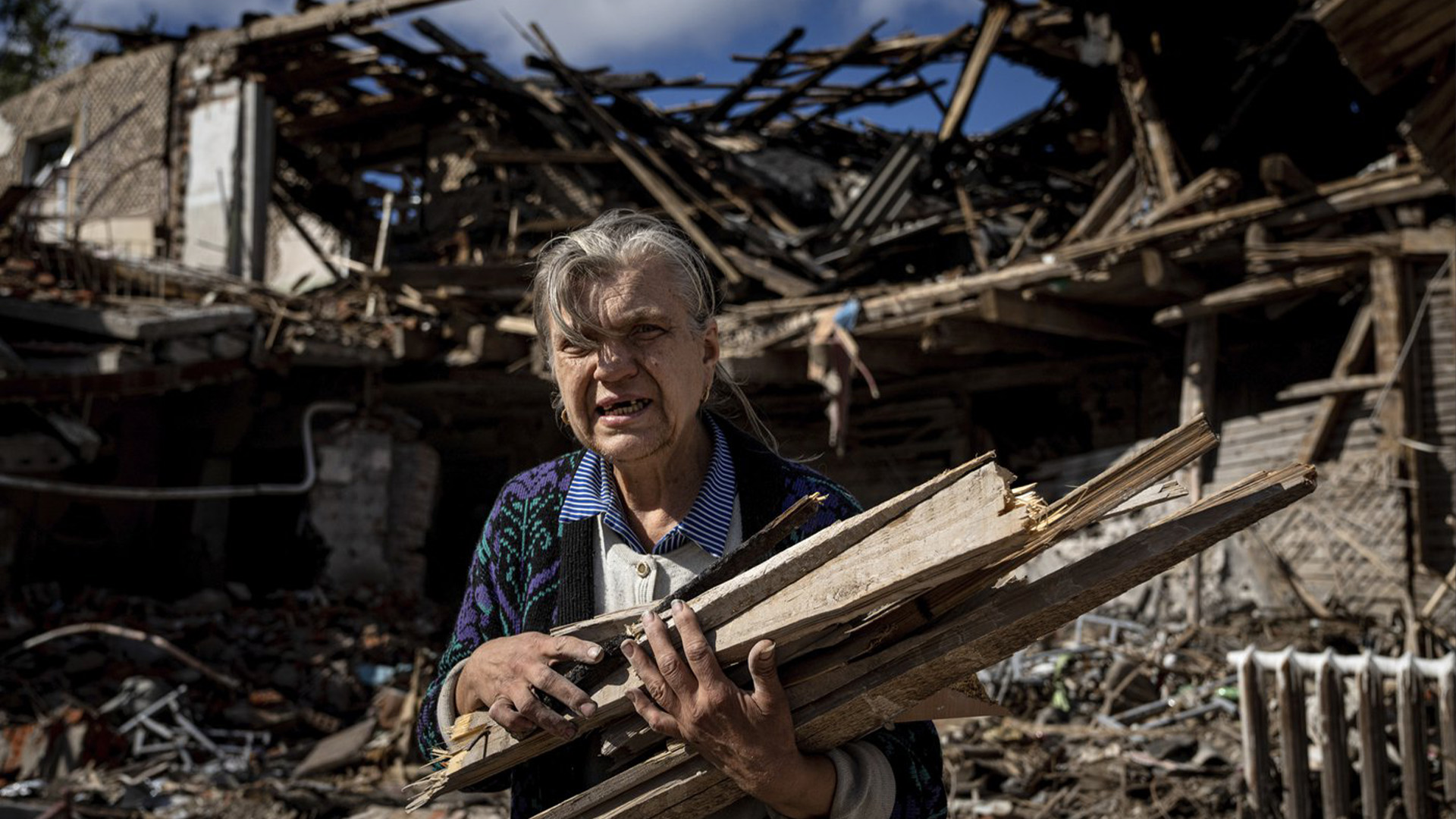 Une femme récupère du bois pour le chauffage dans une école détruite où les forces russes étaient basées dans la région récemment reprise d'Izium, en Ukraine, le lundi 19 septembre 2022.