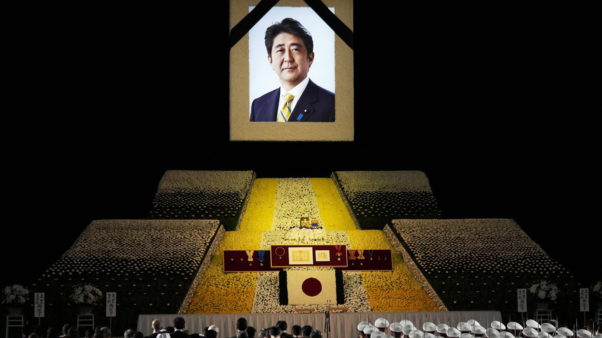 Un portrait de l'ancien Premier ministre japonais Shinzo Abe est accroché sur scène lors de ses funérailles d'État, le mardi 27 septembre 2022, à Tokyo. Abe a été assassiné en juillet.