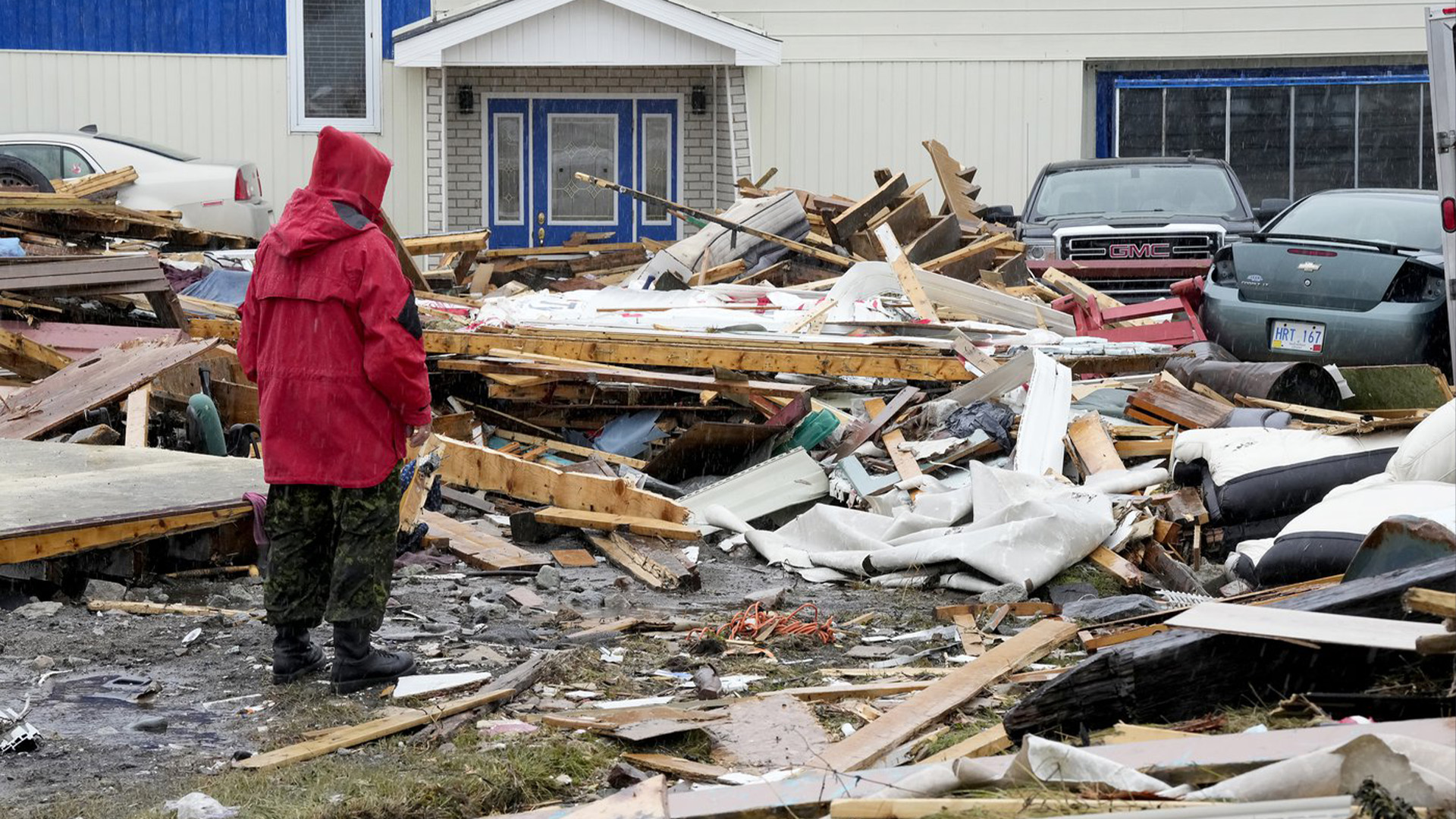 Un Ranger des Forces canadiennes examine les dommages causés à une maison à Port aux Basques, T.-N.-L., le lundi 26 septembre 2022. Dans les Maritimes, dans l'est du Québec et dans le sud-ouest de Terre-Neuve, l'impact économique de la colère de la tempête post-tropicale Fiona est toujours en cours d'évaluation.