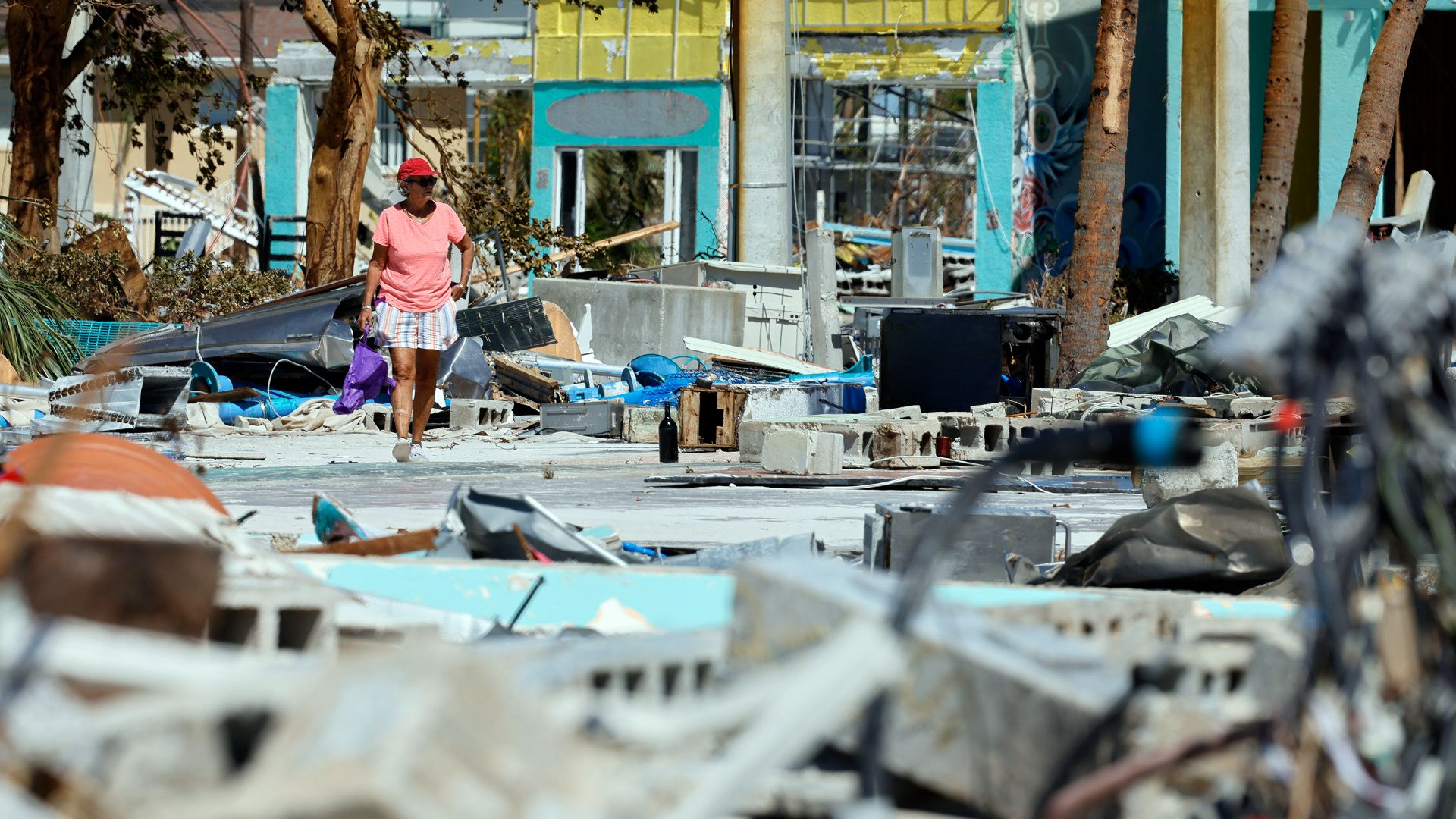 Ana Kapel marche au milieu des débris laissés par l'ouragan Ian à Fort Myers, Floride.