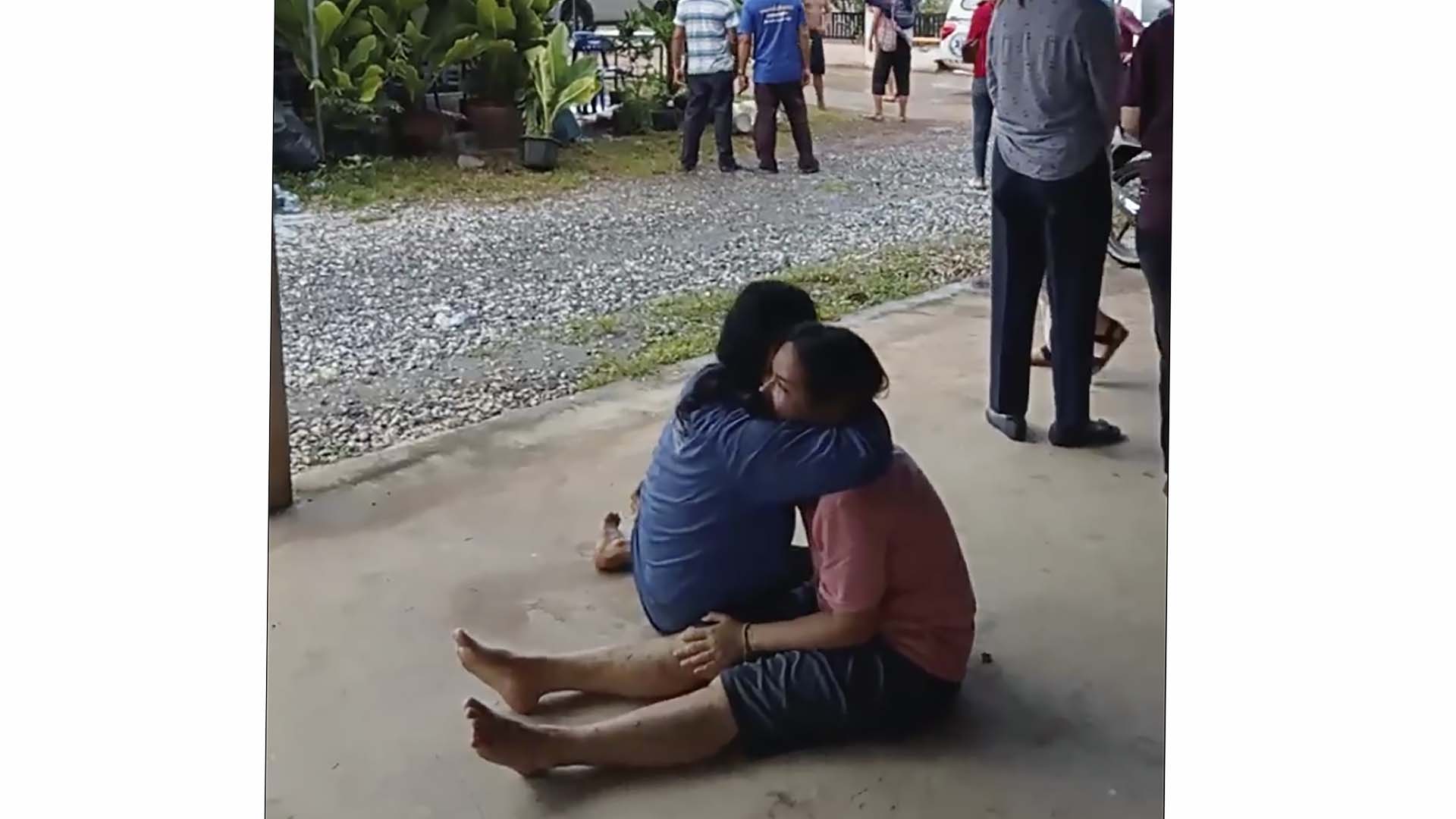 Dans cette image tirée d'une vidéo, une femme désemparée est réconfortée devant le site d'une attaque dans une garderie, le jeudi 6 octobre 2022, dans la ville de Nongbua Lamphu, au nord-est de la Thaïlande. Plus de 30 personnes, principalement des enfants, ont été tuées jeudi lorsqu'un homme armé a ouvert le feu dans la garderie, ont annoncé les autorités. (Groupe de secours Mungkorn Sriboonreung via AP)
