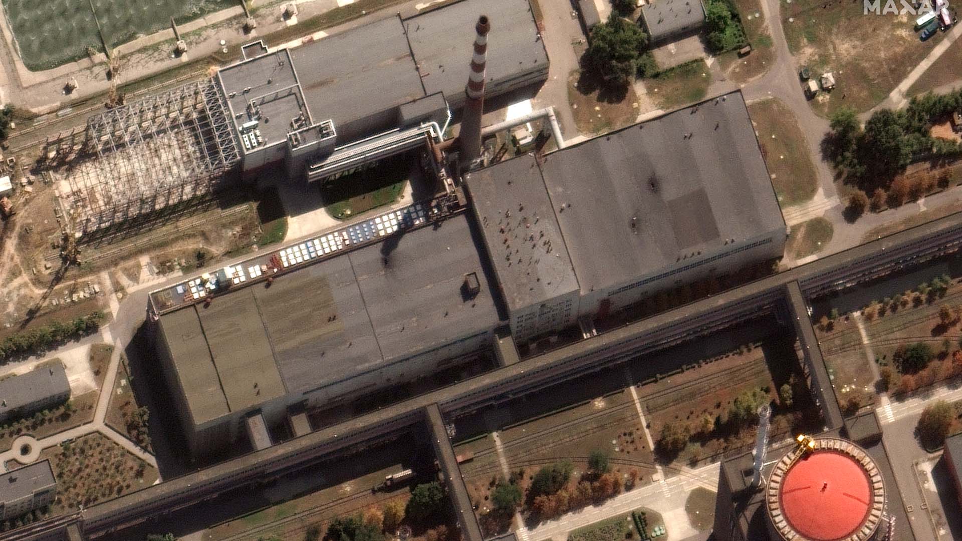 Cette image satellite fournie par Maxar Technologies montre les récents dommages causés au toit d'un bâtiment adjacent à plusieurs des réacteurs nucléaires de la centrale nucléaire de Zaporizhzhia, en Ukraine occupée par la Russie, le 29 août 2022.