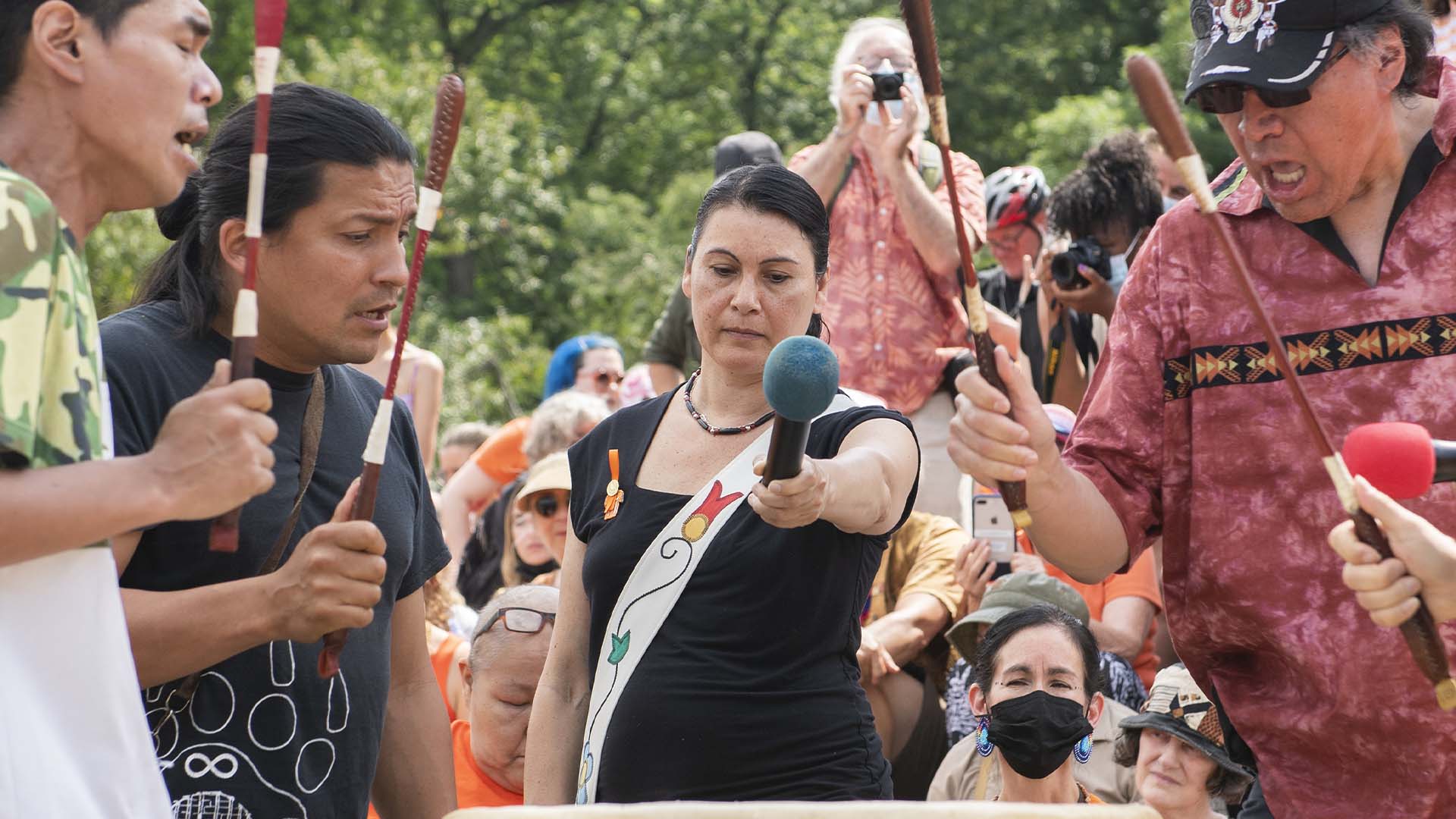 Nakuset, au centre, directrice générale du Foyer pour femmes autochtones de Montréal, avec des batteurs de tambour lors d'un rassemblement à Montréal, le 1er juillet 2021.