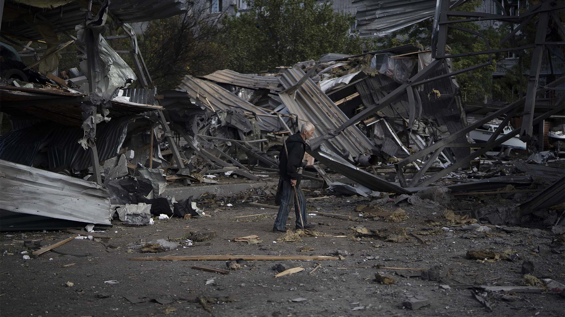 Un homme âgé passe devant un magasin de voitures qui a été détruit après une attaque russe à Zaporizhzhia, en Ukraine, le mardi 11 octobre 2022. 