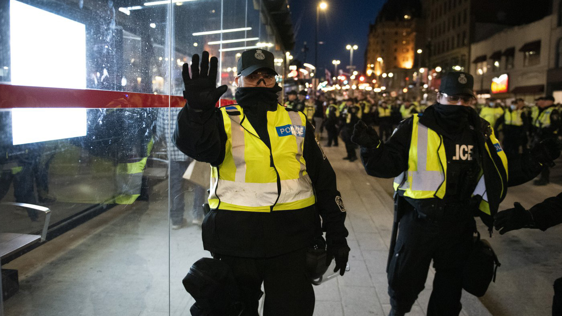 La police demande aux gens de reculer alors qu'ils travaillent à dégager la rue Rideau des véhicules lors d'une manifestation à Ottawa, le vendredi 29 avril 2022.