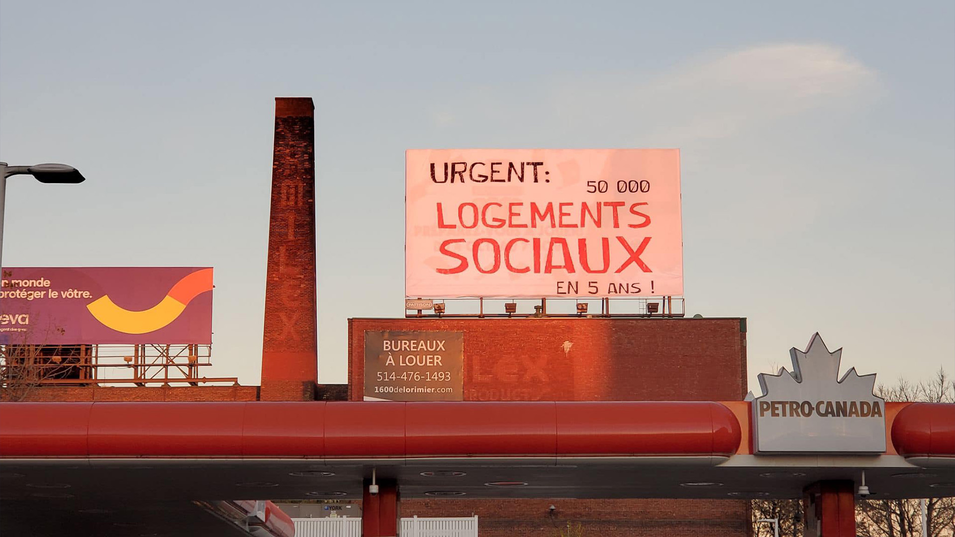 Le FRAPRU lance un message au gouvernement de la CAQ avec une bannière géante affichée au pied du pont Jacques-Cartier à Montréal, le jeudi 3 novembre 2022, où l'on peut lire: «Urgent : 50 000 logements sociaux en 5 ans».