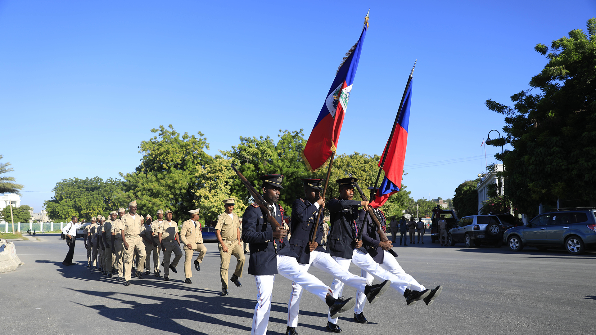 Des soldats paradent devant le Palais national.