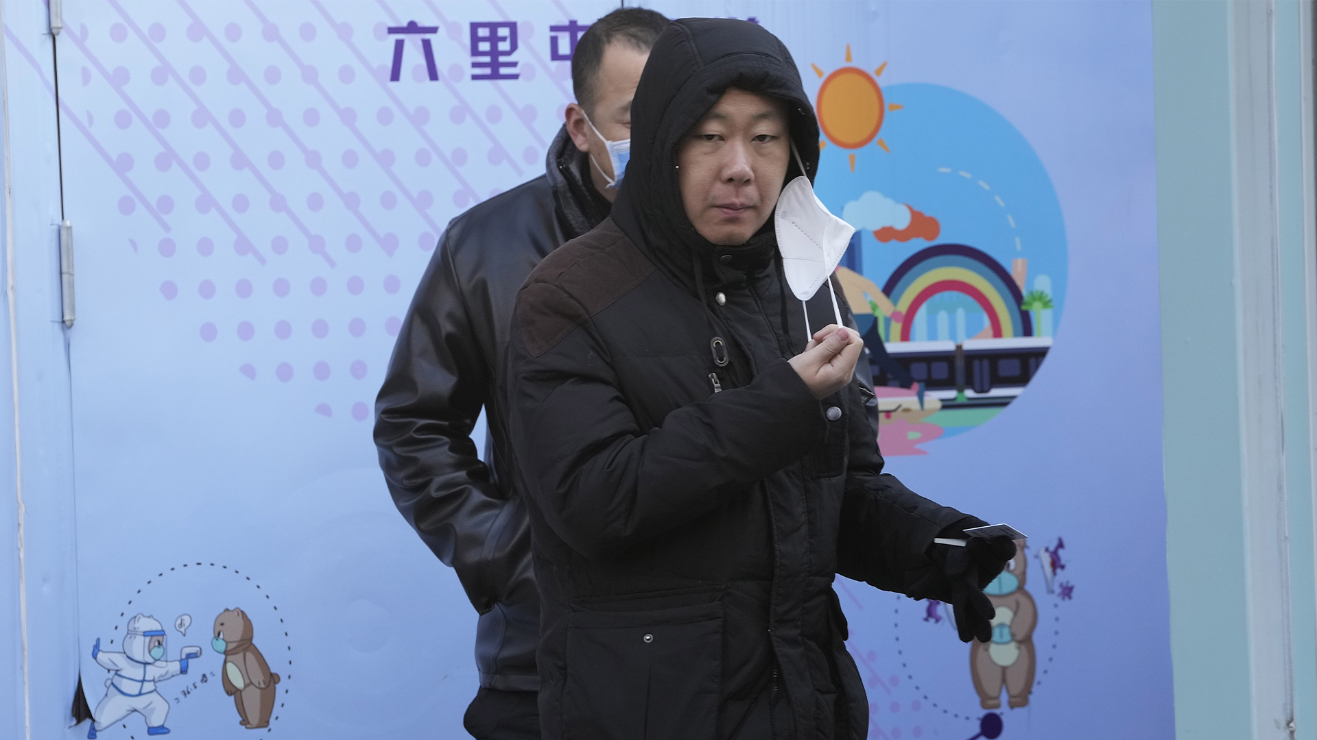Un résident retire un masque lors d'un test COVID à Pékin, le mercredi 7 décembre 2022. Dans un net revirement, la Chine a annoncé une série de mesures annulant certaines des restrictions anti-COVID-19 les plus draconiennes. ()