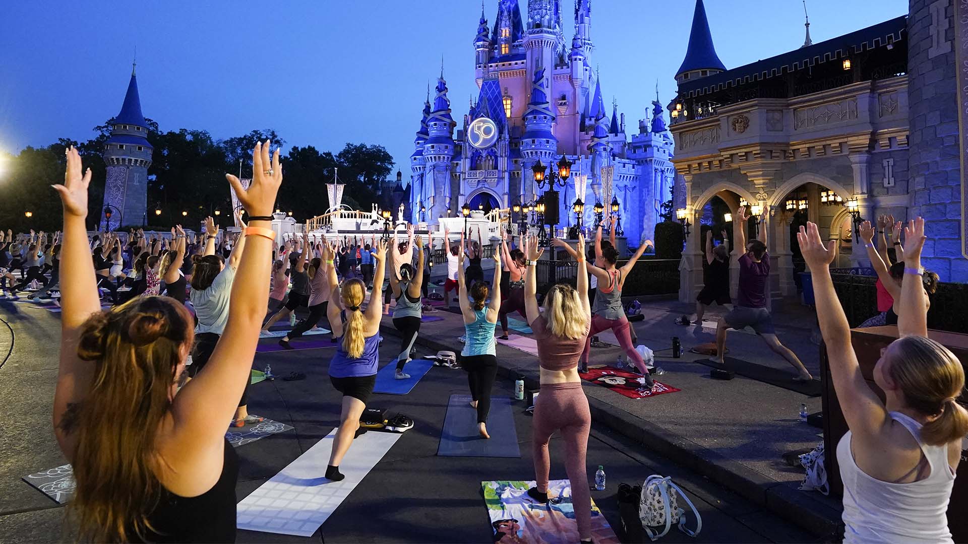 Près de 2 000 personnes pratiquent le yoga au lever du soleil pour célébrer la Journée internationale du yoga devant le château de Cendrillon au parc Magic Kingdom de Walt Disney World le mardi 21 juin 2022 à Lake Buena Vista, en Floride.