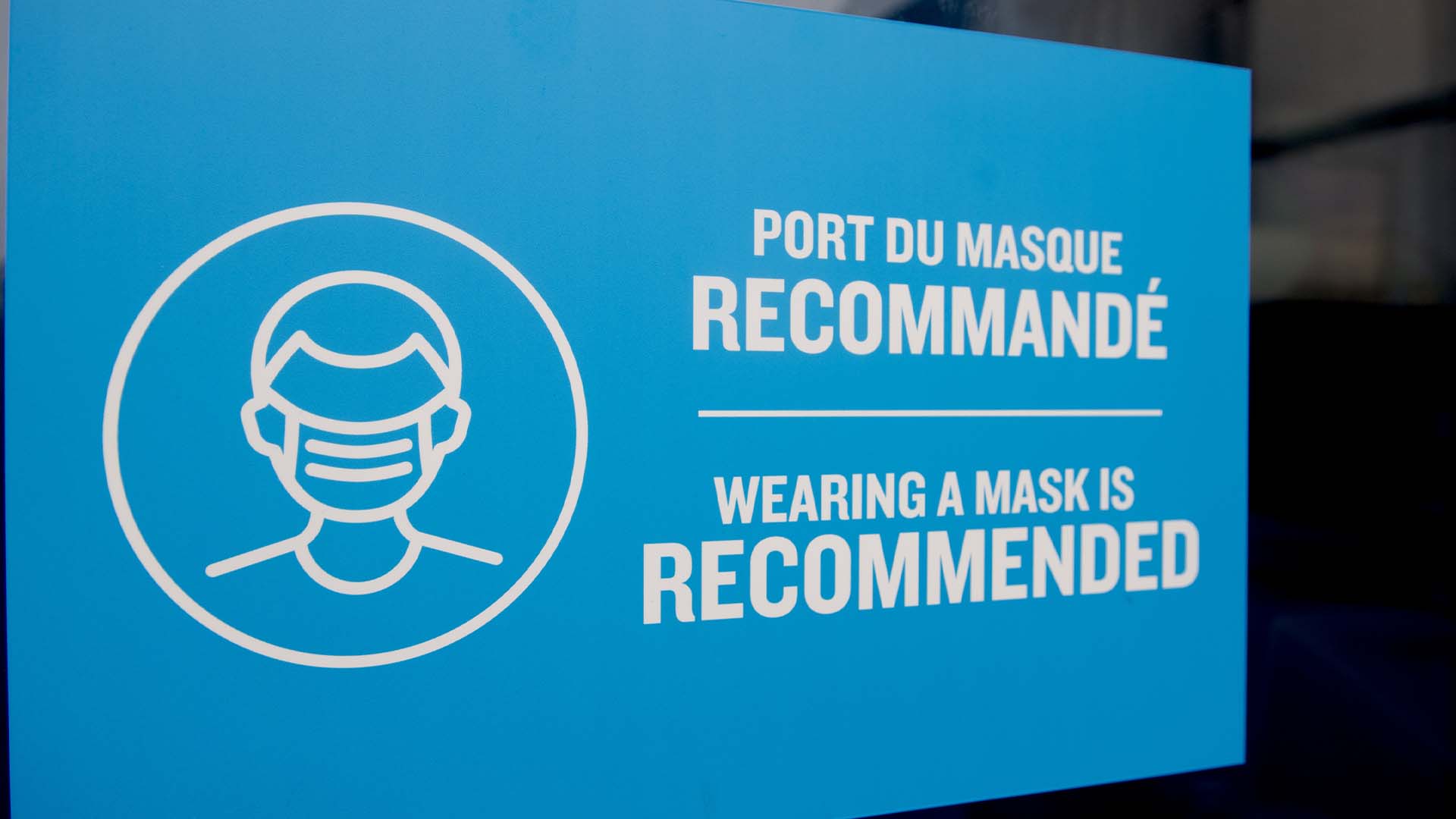 Un panneau indiquant «le port d'un masque recommandé» est accroché sur une porte au Vieux-Port de Montréal, le 1er janvier 2023.