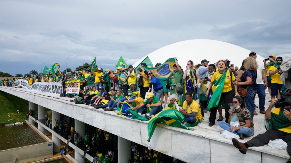 Des manifestants, partisans de l'ancien président brésilien Jair Bolsonaro, se tiennent sur le toit du bâtiment du Congrès national après l'avoir pris d'assaut, à Brasilia, au Brésil, le 8 janvier 2023.