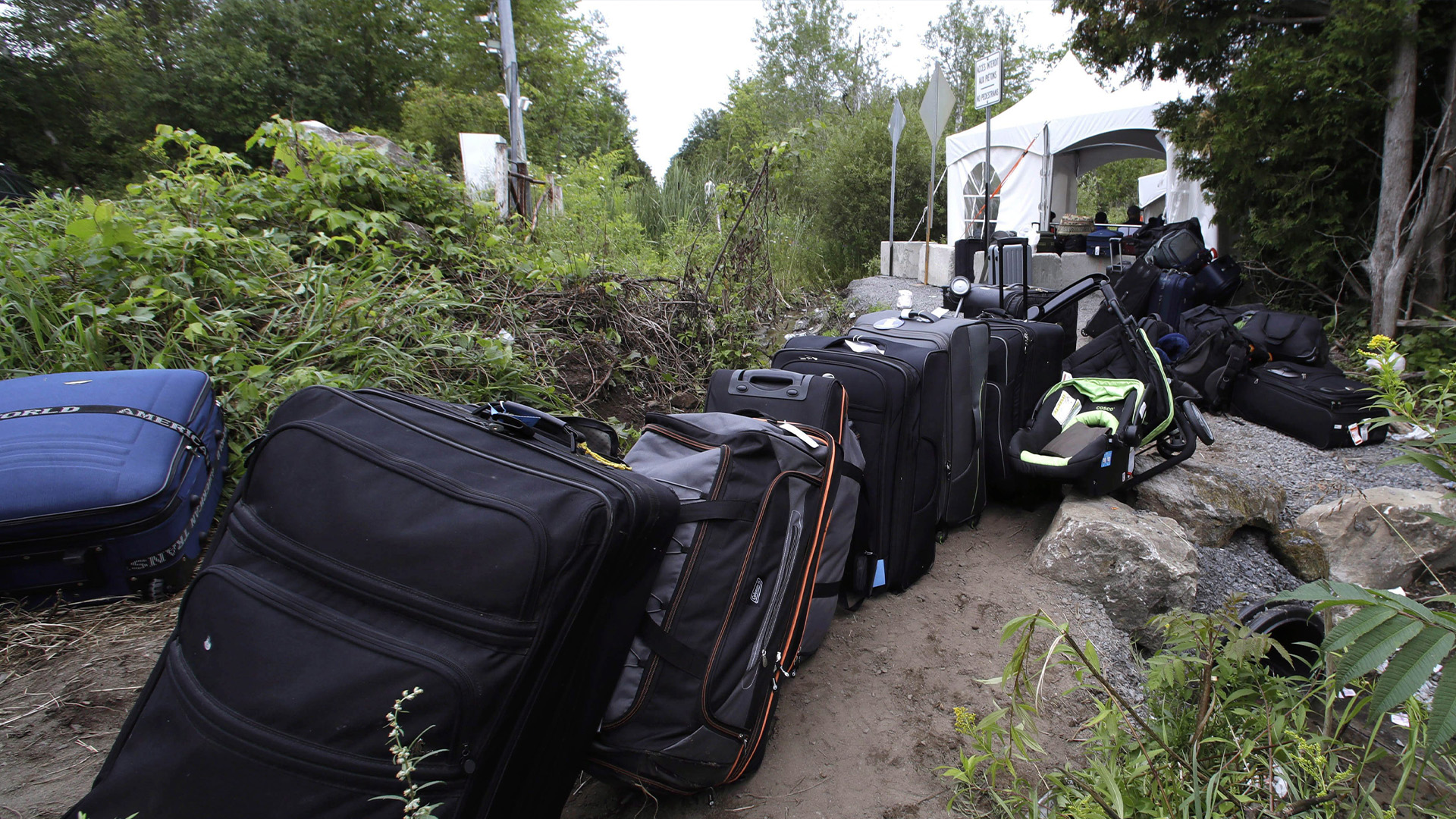 Les bagages des migrants remplissent une voie à un point de passage illégal de Champlain, N.Y., à Saint-Bernard-de-Lacolle, Québec, le lundi 7 août 2017.