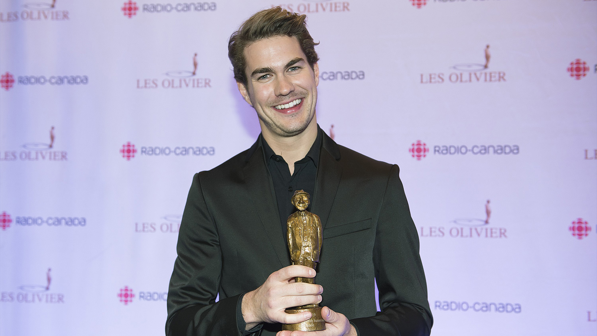 Julien Lacroix brandit son trophée lors de la remise des prix Gala Olivier à Montréal le 8 décembre 2019.