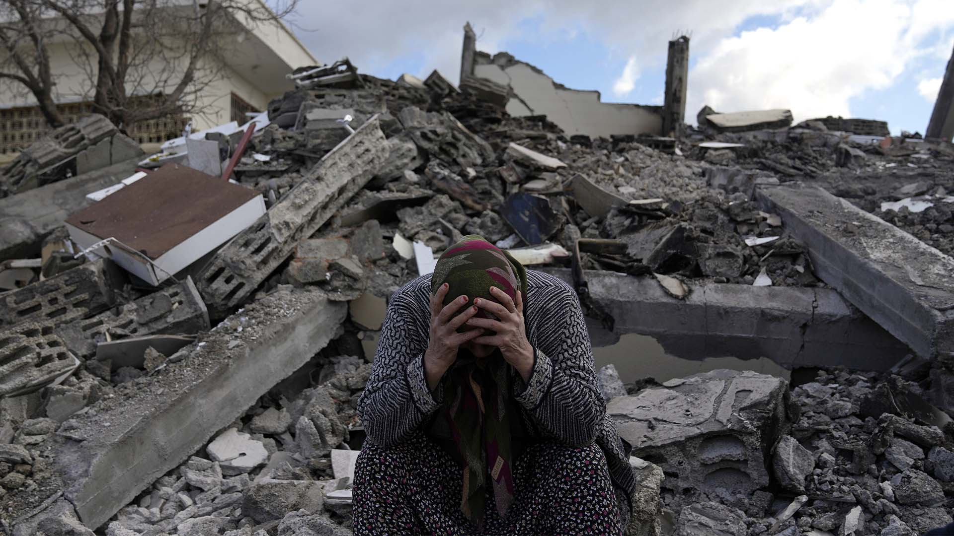 Une femme est assise sur les décombres alors que des équipes de secours d'urgence recherchent des personnes sous les restes de bâtiments détruits dans la ville de Nurdagi, à la périphérie de la ville d'Osmaniye, dans le sud de la Turquie, le mardi 7 février 2023. Un puissant tremblement de terre a frappé le sud-est de la Turquie et la Syrie tôt lundi, renversant des centaines de bâtiments et tuant et blessant des milliers de personnes. 