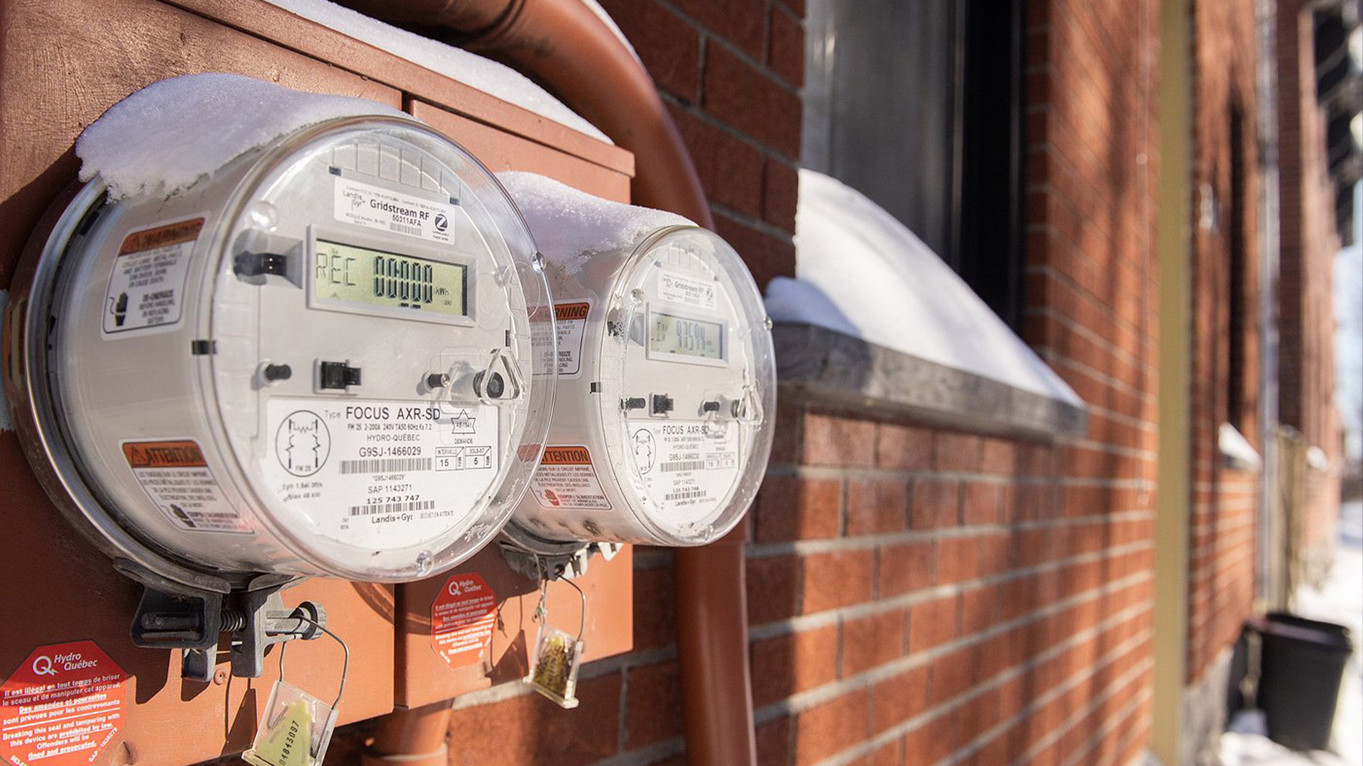 Des compteurs d'électricité sont affichés sur le côté des maisons à Montréal, le samedi 4 février 2023.