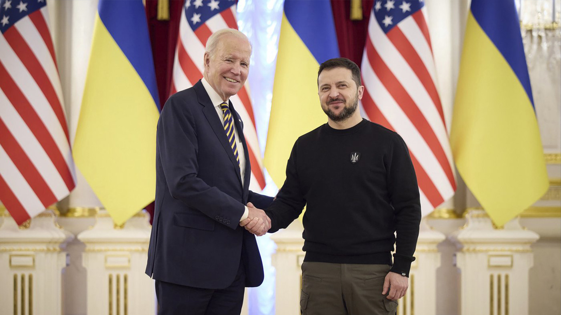 Dans cette image tirée d'une vidéo fournie par le Bureau de presse présidentiel ukrainien et publiée sur Facebook, le lundi 20 février 2023, le président ukrainien Volodymyr Zelenskyy, à droite, et le président américain Joe Biden se serrent la main lors de leur rencontre à Kyiv, en Ukraine.