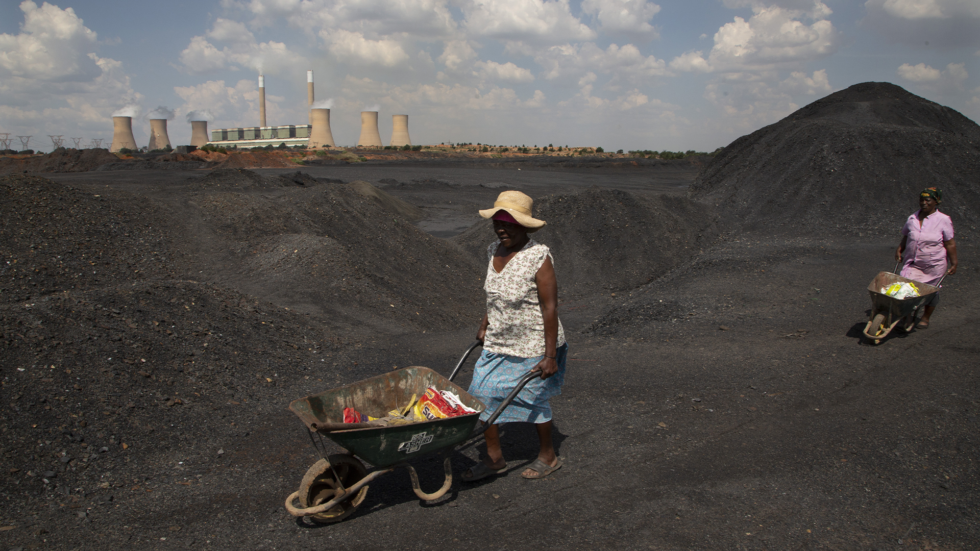 Des femmes poussent des brouettes au sommet d'une décharge de mine de charbon à la centrale électrique au charbon de Duvha, près d'Emalahleni à l'est de Johannesburg, le 17 novembre 2022