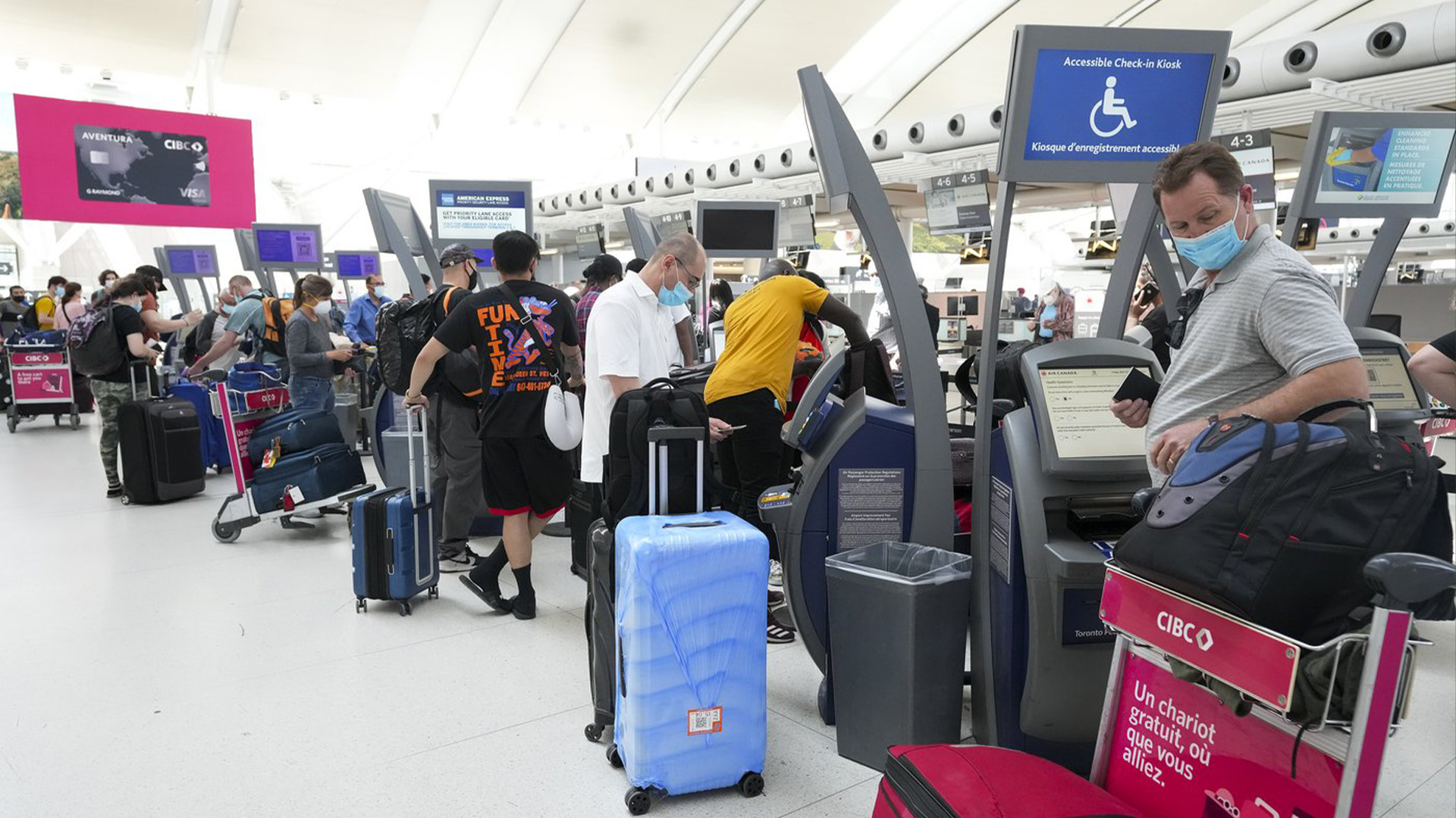 Les gens font la queue pour s'enregistrer à l'aéroport international Pearson de Toronto le jeudi 12 mai 2022. Les voyageurs canadiens font face à une augmentation des frais d'aéroport après que la pandémie ait anéanti les revenus et entraîné une accumulation de dettes pour les aéroports à travers le pays.