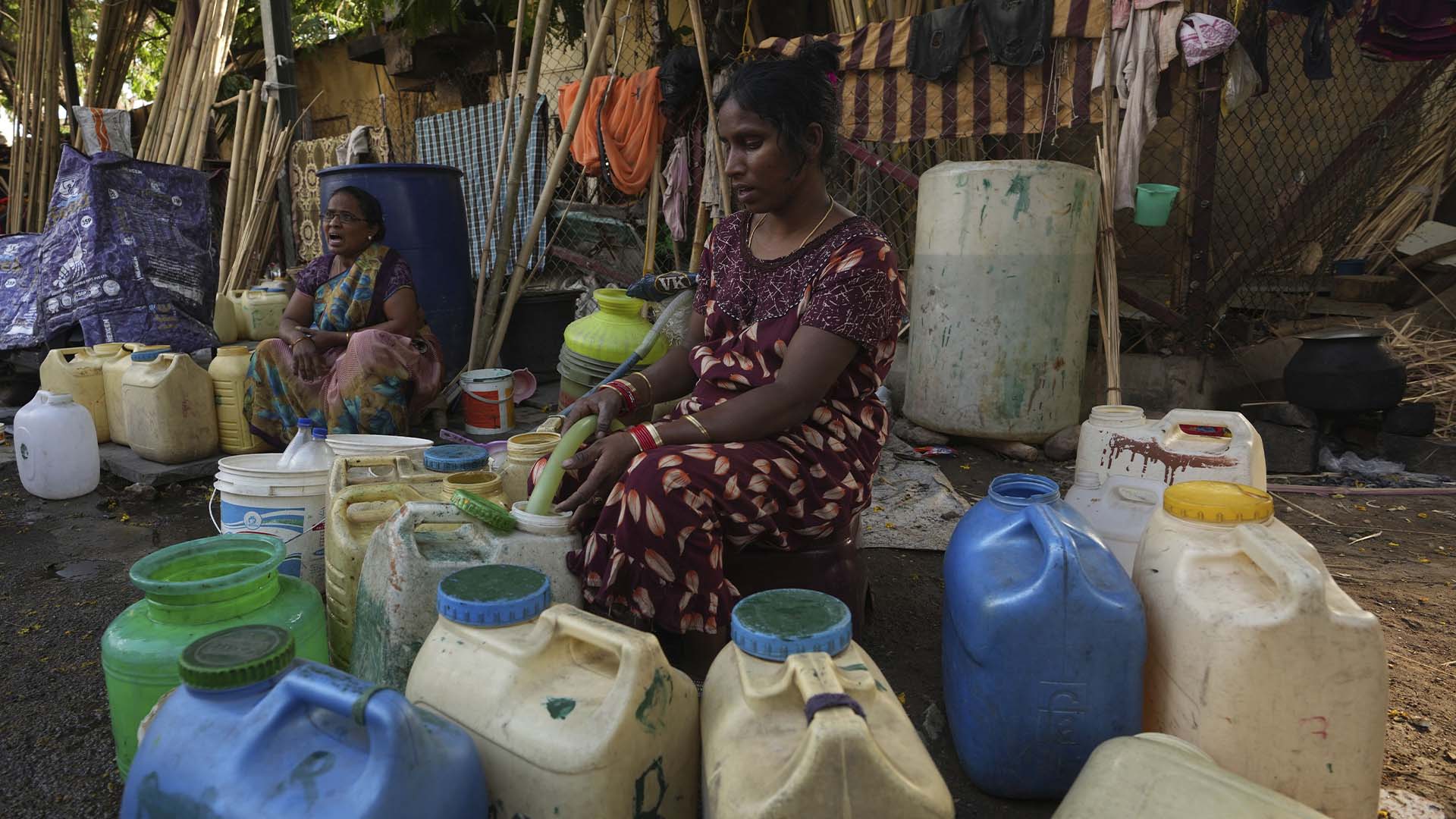 Des femmes puisent de l'eau à un robinet public dans un bidonville d'Hyderabad, en Inde, le mercredi 22 mars 2023. La Journée mondiale de l'eau est célébrée chaque année le 22 mars. (AP Photo/Mahesh Kumar A.)